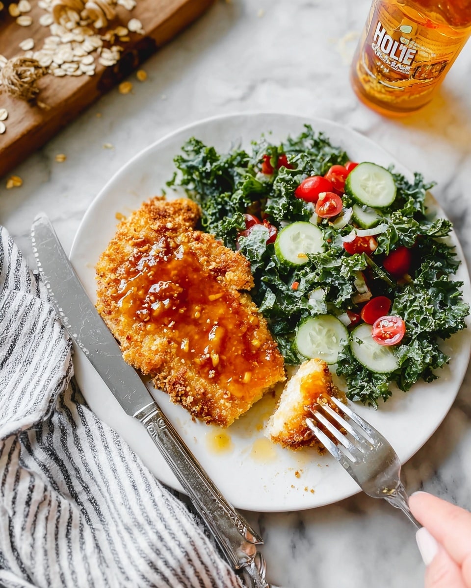 A white plate on a white marbled surface holds a golden brown breaded piece of chicken topped with a shiny honey glaze on the left side, and a fresh green salad on the right side containing kale, cherry tomatoes, cucumber chunks, and some finely chopped red pieces. A silver fork held by a woman's hand is cutting a small piece from the chicken in the foreground, while a silver knife rests near the salad on the plate. The background has a honey bottle and a wooden board with some oats on it. A striped cloth is partially visible near the bottom left corner photo taken with an iphone --ar 4:5 --v 7