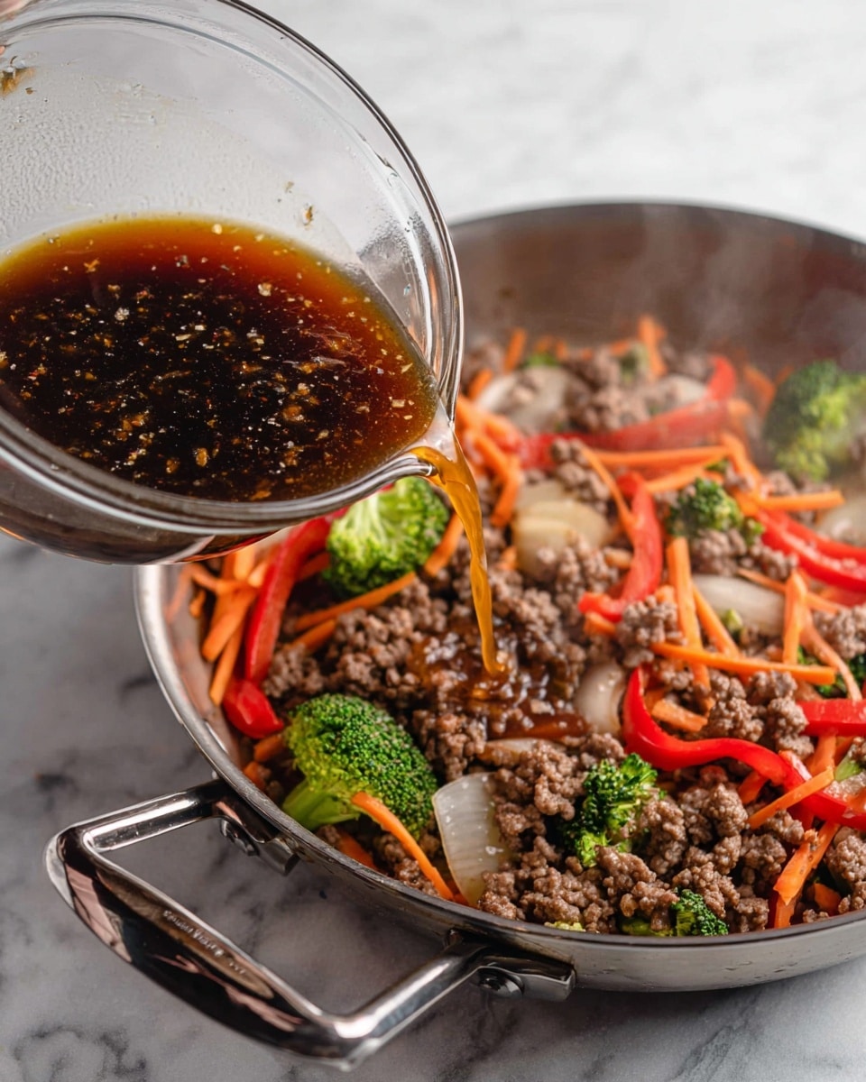 A white woman's hand holds a clear glass bowl pouring a dark brown sauce with visible small bits over a pan filled with cooked ground meat mixed with sliced red bell peppers, sliced light orange carrots, small green broccoli florets, and translucent cooked onion slices. The pan has a shiny metal handle and is placed on a white marbled surface, with steam rising slightly from the food. Photo taken with an iphone --ar 4:5 --v 7