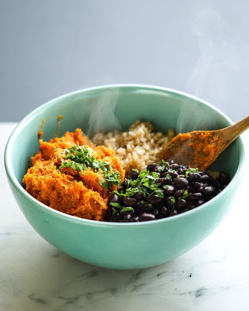 A light turquoise bowl holds three separate layers of food. On the left is a bright orange mashed layer, topped with small green chopped herbs. To the right of this is a light brown cooked rice layer with a soft texture. In front of the rice and orange mash is a layer of shiny black beans, also garnished sparsely with green herbs. A wooden spoon with some orange residue on its tip rests on the right side inside the bowl. The background and surface are white with a marbled texture. Steam rises gently above the bowl, showing the food is warm. Photo taken with an iphone --ar 4:5 --v 7