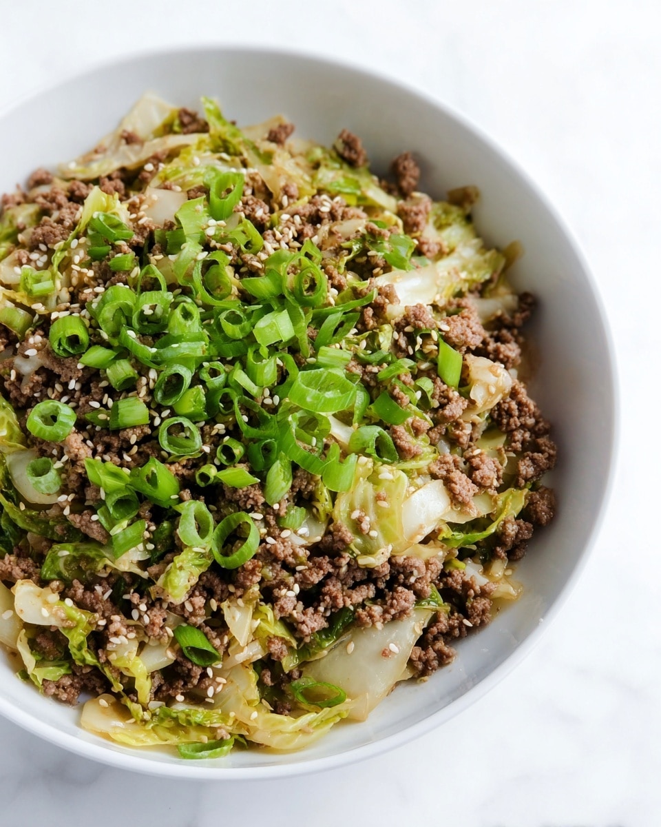 The dish is served in a white bowl filled with a mix of cooked ground beef and soft, pale green cabbage pieces forming the bottom layer. On top, fresh bright green chopped spring onions are scattered evenly, adding a fresh contrast. Small white sesame seeds are sprinkled over the top, giving a textured look. The bowl sits on a white marbled surface. photo taken with an iphone --ar 4:5 --v 7