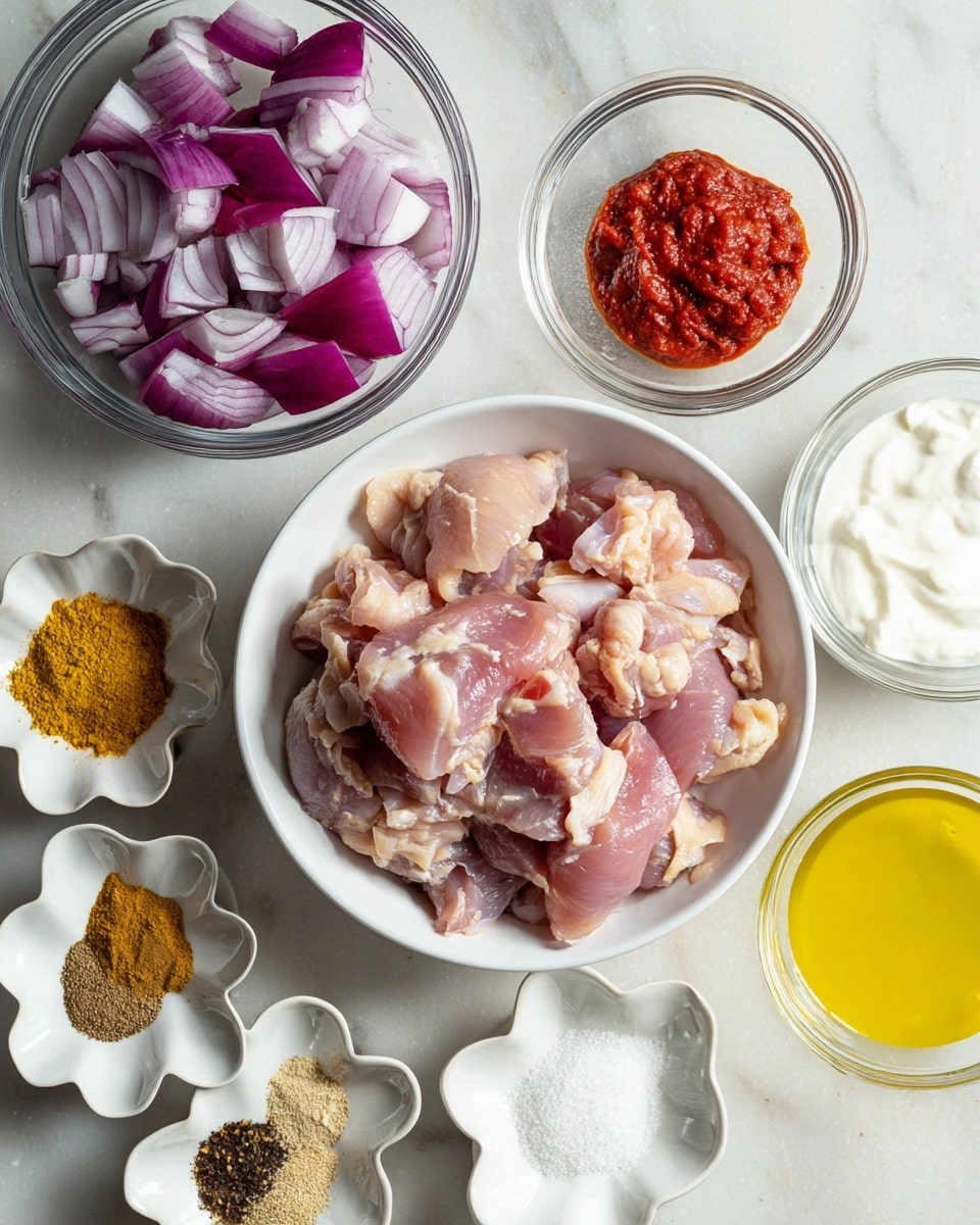 The image shows raw chicken pieces in a white round bowl placed in the middle. To the top left, there is a clear glass bowl filled with large chunks of purple-red onion. Surrounding the chicken bowl are small white flower-shaped bowls holding different ingredients: bright red tomato paste at the top right, golden yellow oil slightly below it, minced garlic and ginger on the bottom left, and a mix of brown and yellow spices along with plain white salt and creamy white yogurt in smaller bowls at the bottom. All items are arranged on a white marbled surface. photo taken with an iphone --ar 4:5 --v 7