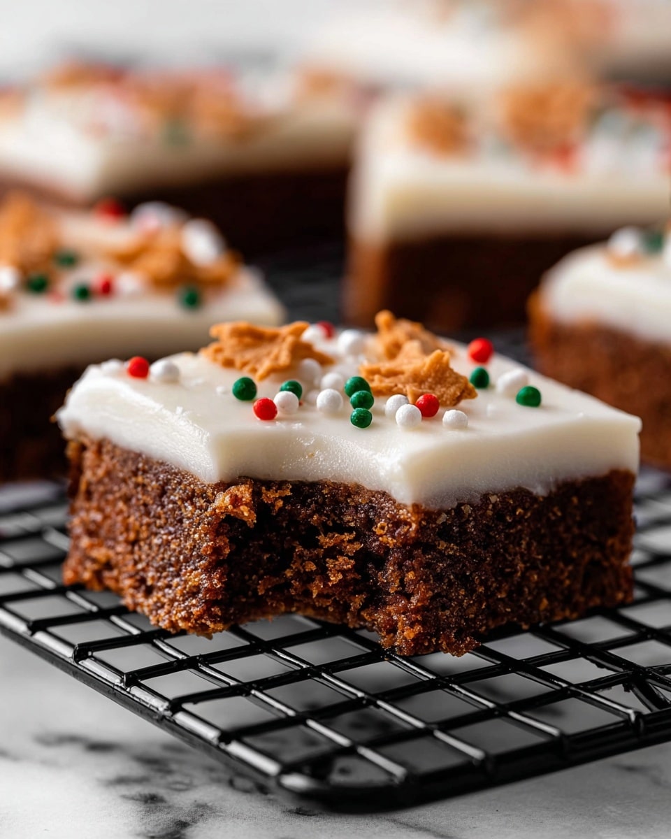 The image shows a close-up of a square dessert bar on a black wire cooling rack with a white marbled surface below. The dessert has two layers: the bottom layer is dense and dark brown with a slightly crumbly texture, while the top layer is thick, smooth white frosting with a creamy texture. On top of the frosting, there are small, colorful round sprinkles in red, green, and white, and flat orange-brown shaped sprinkles scattered across the surface. The front dessert bar has a bite taken out of the corner, showing both layers clearly. In the blurred background, other pieces of the dessert are visible. Photo taken with an iphone --ar 4:5 --v 7