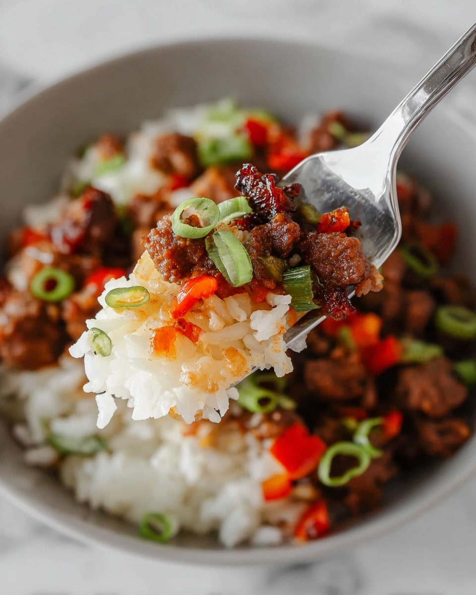 The image shows a close-up of a dish with one layer of white rice that has a soft texture and separate grains, topped with a layer of small brown pieces of cooked meat that have a slight shine and browned edges. Mixed in are small chunks of red vegetables, likely bell peppers, adding bright color. Thin green rings of scallions are sprinkled over the top, adding freshness and a touch of green contrast. The dish is served in a white bowl on a white marbled surface, and a fork holding a small portion with all the layers is capturing focus in the center. Photo taken with an iphone --ar 4:5 --v 7