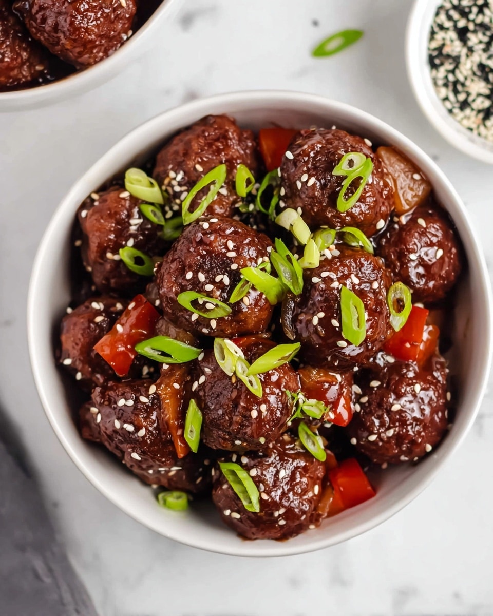 A white bowl filled with about ten dark brown meatballs covered in a thick shiny dark sauce, mixed with small square pieces of red bell pepper. The meatballs and peppers are topped with white and black sesame seeds scattered over them, and thin green rings of sliced green onions are spread on top. The bowl is on a white marbled surface with parts of another white bowl filled with more meatballs and a third bowl filled with black and white sesame seeds visible nearby. Photo taken with an iphone --ar 4:5 --v 7