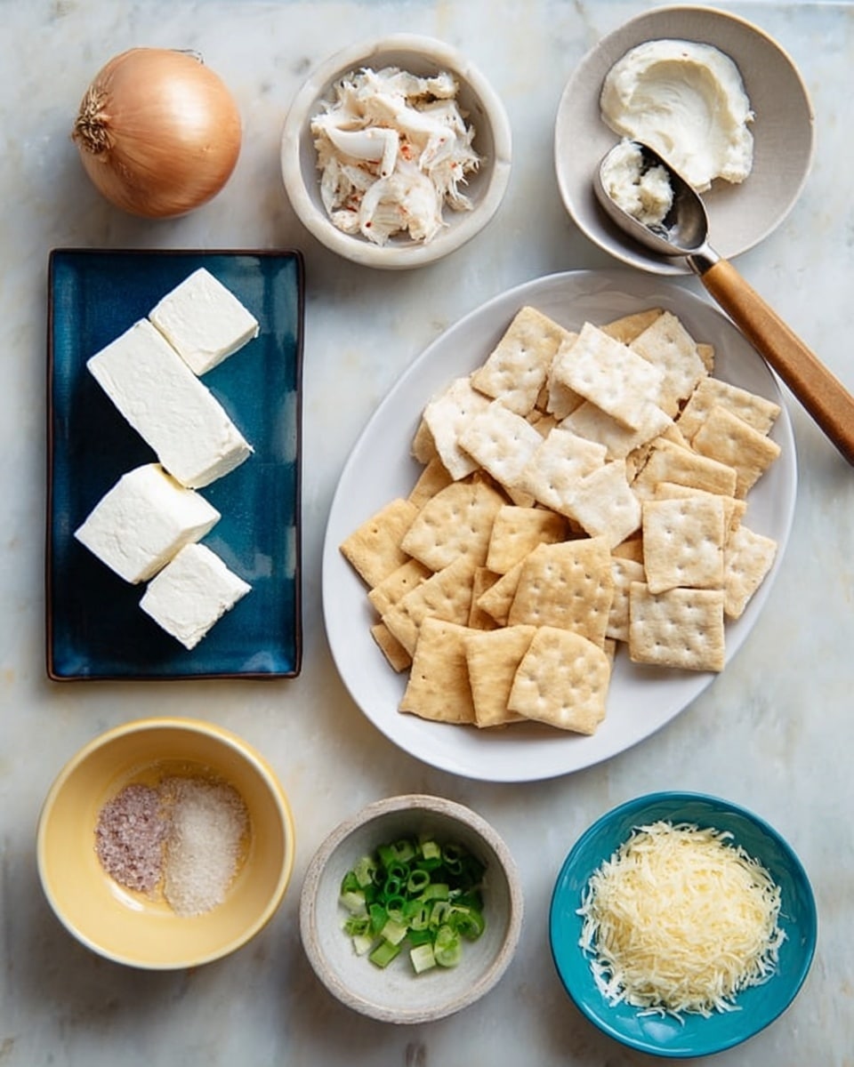 The image shows an arrangement of ingredients on a white marbled surface. There is a white oval plate on the right filled with beige crackers in different shapes and sizes, including rectangular and round ones. Next to it, a wooden utensil with a metal scoop holds a dollop of pale cream. Above the scoop, a small white bowl contains shredded white crab meat. To the left, a whole brown onion rests below a dark blue rectangular plate stacked with several white cream cheese squares. Below the onion and cheese, a small round yellow bowl holds a mix of white salt and pink seasoning. A tiny white square bowl with chopped green onions and a small round bowl with chopped garlic sit nearby. Finally, a turquoise bowl contains a sprinkle of light yellow grated cheese. Photo taken with an iphone --ar 4:5 --v 7
