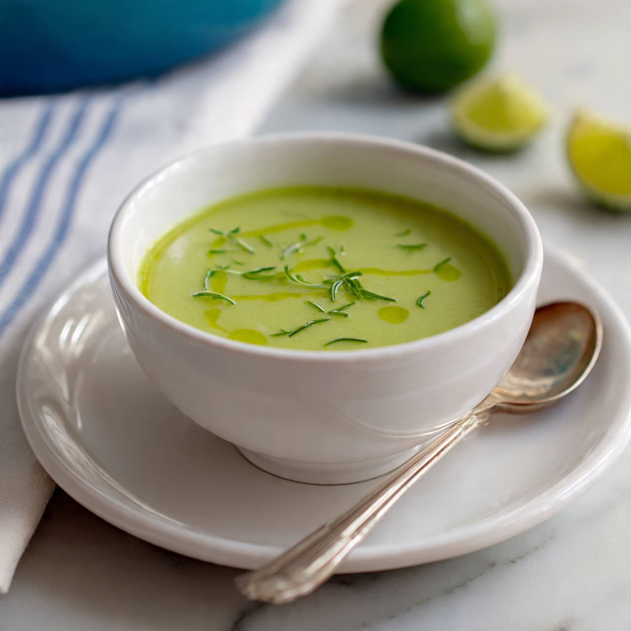 A round light blue pot filled with smooth, bright green soup sits on a black stove with visible metal grates, beside a white marbled countertop. The soup has a uniform texture with a few small bubbles on the surface, filling the pot almost to the top, showing a light yellow inner lining. Photo taken with an iphone --ar 4:5 --v 7