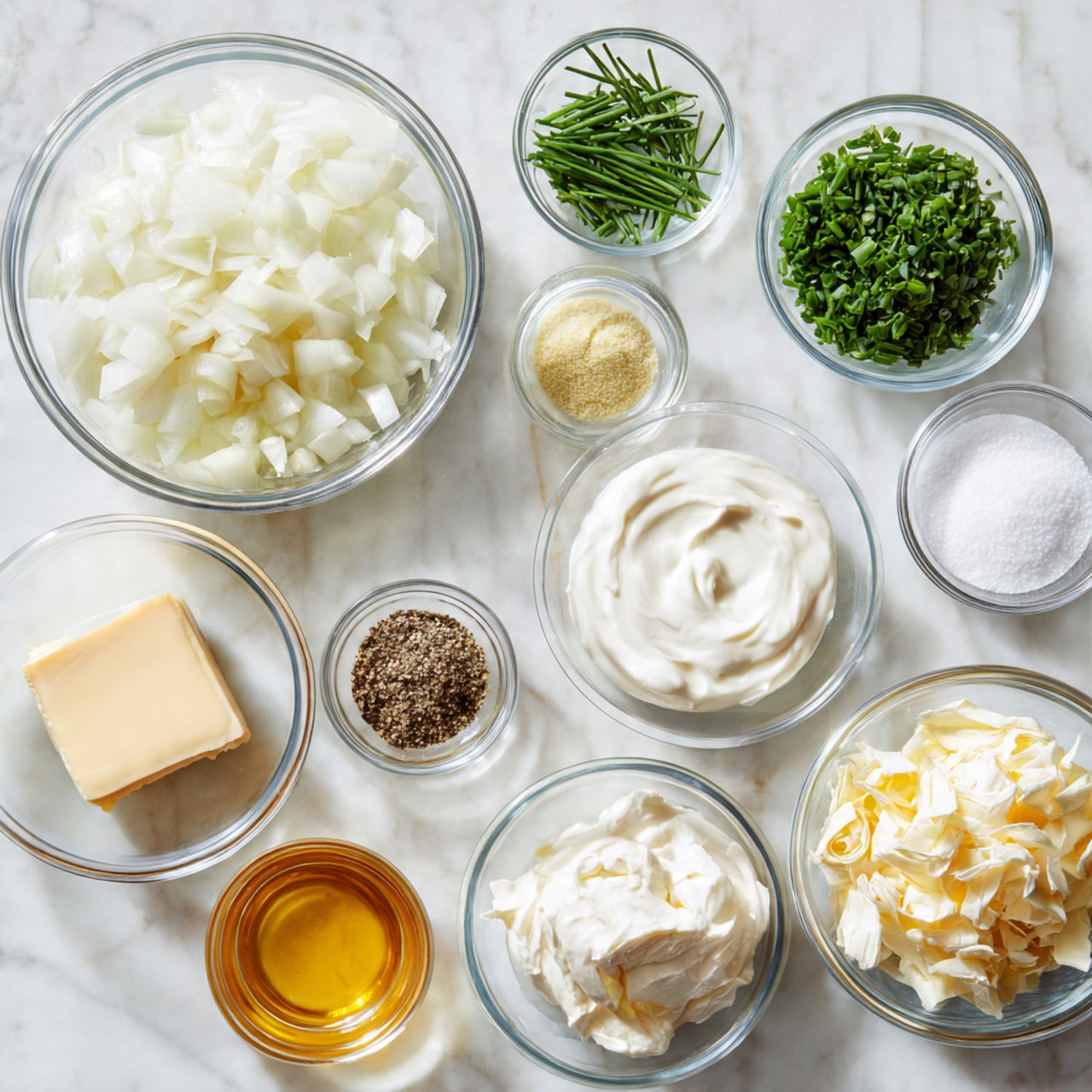 The image shows eleven clear glass bowls arranged on a white marbled surface. The largest bowl on the left is filled with chopped white onions with a smooth, translucent texture. To its right, a small bowl contains white salt, and next to it is a bowl with finely chopped green chives. Above the chives is a bowl holding thick white sour cream with a soft, creamy texture. Below the sour cream is a tiny bowl filled with light yellow powder, possibly garlic powder. In the center, a bowl has a small pile of chopped green herbs with a rough texture. Below it, a bowl contains black pepper powder, and next to this, another bowl has a golden-yellow liquid, likely vanilla or honey. On the bottom left, one bowl holds a block of smooth cream cheese, and next to it is a bowl with a pale yellow slab of butter. Finally, the lower right bowl has a mound of soft, off-white mayonnaise with a whipped texture. The photo taken with an iphone --ar 4:5 --v 7