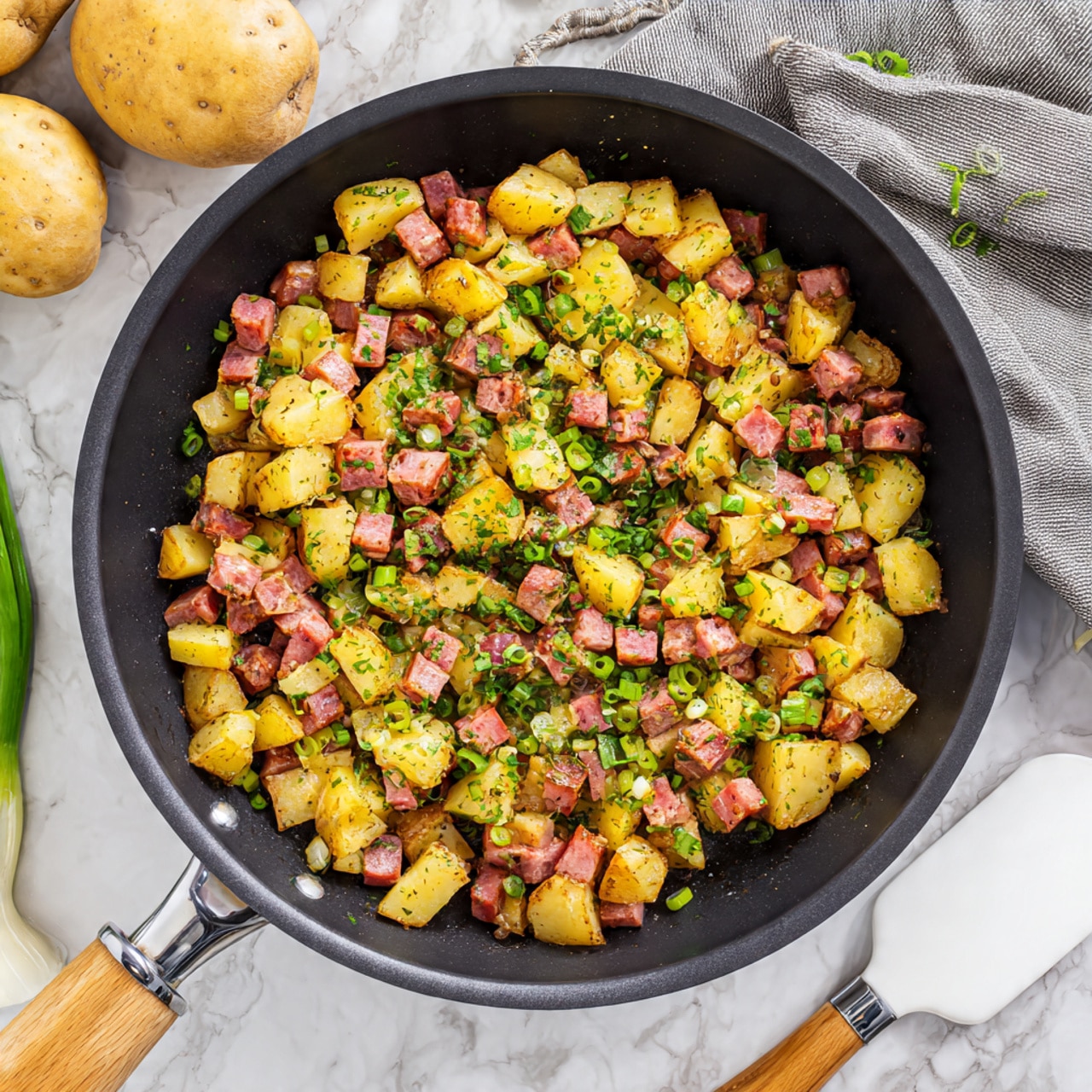 A white plate shows a dish with three main layers: the bottom layer is a mix of golden brown diced potatoes and dark pink pieces of meat, mixed with some green herbs; on top of this is a white fried egg with a slightly broken yolk, releasing bright yellow runny yolk over the potatoes and meat; on the side, there is a single triangular piece of golden toasted bread spread with light butter. A silver fork is placed on the plate, touching the potatoes and egg. The plate sits on a white marbled surface with a bunch of green onions on the left, a beige bowl holding brown and white eggs on the top right, and a gray cloth with stripes on the bottom right. Photo taken with an iphone --ar 4:5 --v 7