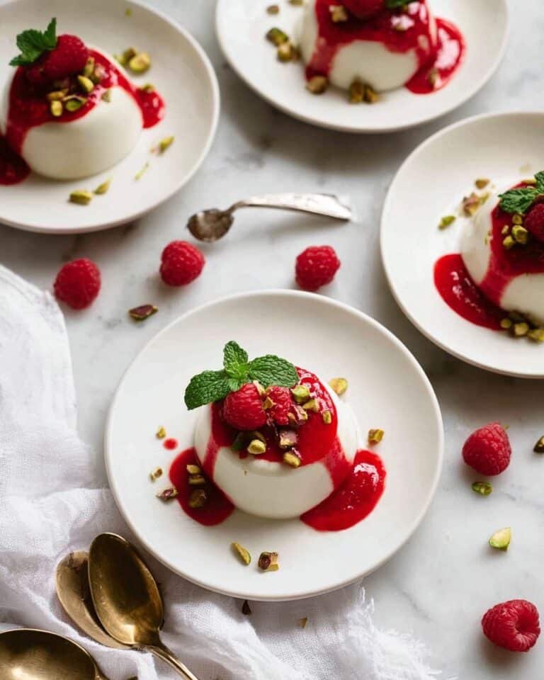 Creamy Vanilla Panna Cotta with Raspberry Coulis and Pistachio Garnish Recipe