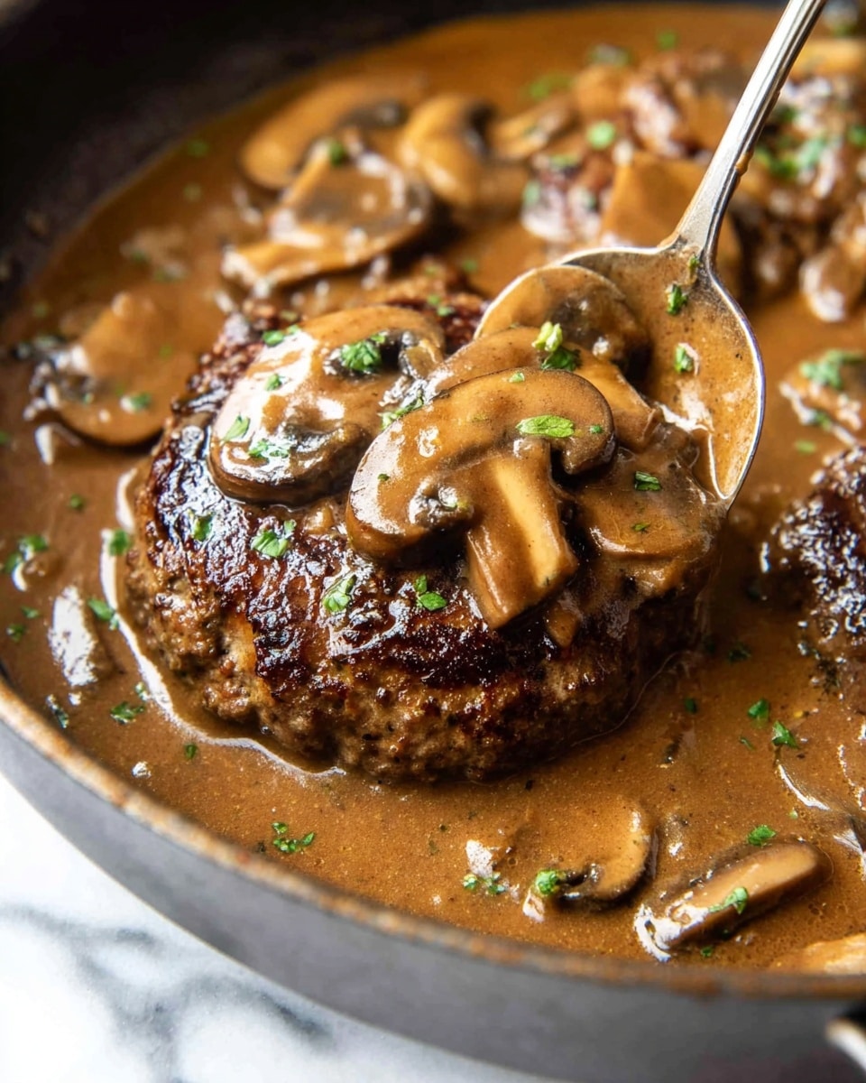 The dish is served on a white plate placed on a white marbled surface. There are three main layers visible: at the back, there is a creamy layer of light beige mashed potatoes, soft and smooth; in the middle, a thick brown meat patty with a slightly charred texture on top is covered with a shiny brown mushroom gravy with slices of light beige mushrooms and small bits of green herbs scattered on top; on the right side, a small pile of vibrant green beans with a glossy texture adds color contrast. A silver fork holds a piece of the meat patty at the front, showing its slightly crumbly inside. Photo taken with an iphone --ar 4:5 --v 7