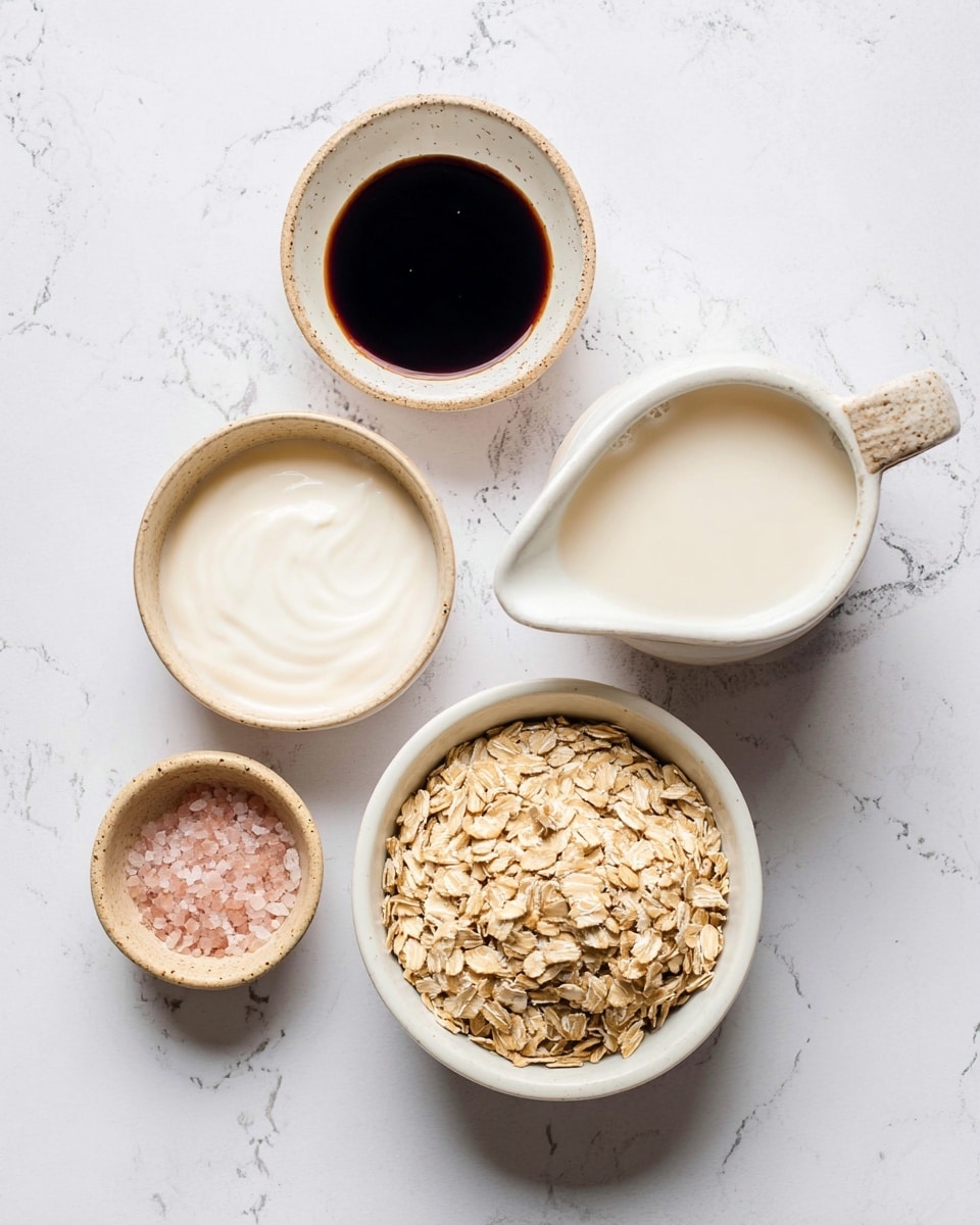 This image shows five small white bowls and a small pitcher, placed on a white marbled surface. The bottom right bowl is filled with light brown rolled oats with a rough texture. Above it to the right is a white pitcher with a rough, light beige handle, filled with creamy white liquid. To the left of the pitcher is a small white bowl with dark, shiny syrup inside. Above it is a light brown textured bowl filled with smooth, white yogurt. At the bottom left is a small beige bowl containing pink salt. The bowls and pitcher are arranged in a loose circular pattern. photo taken with an iphone --ar 4:5 --v 7