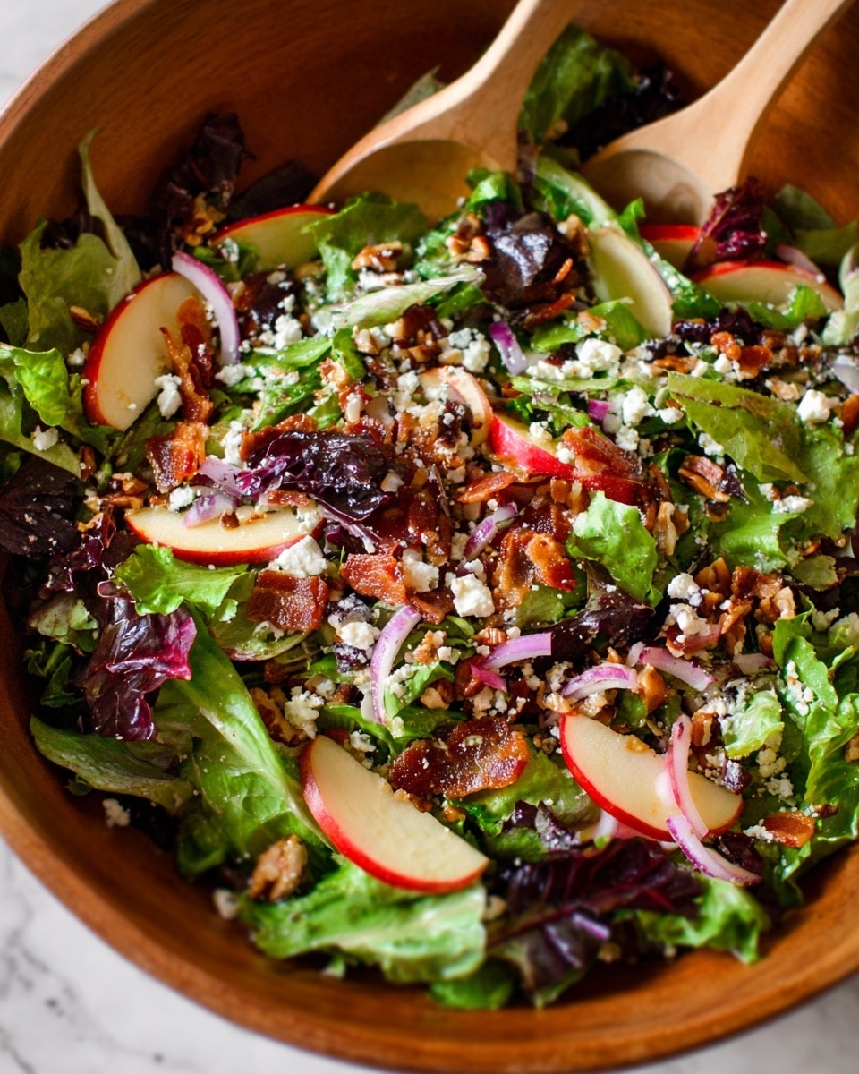 A bowl filled with three main layers: the bottom layer is a mix of green and purple leafy lettuce, giving a fresh and textured feel; the middle layer shows scattered small pieces of crispy bacon in brown color; the top layer features thin red apple slices, thinly sliced red onion rings, small white crumbles of cheese, and small brown nut pieces evenly spread, all creating a colorful and fresh look in the white marbled setting. Two wooden salad spoons hold some salad near the center of the image. photo taken with an iphone --ar 4:5 --v 7