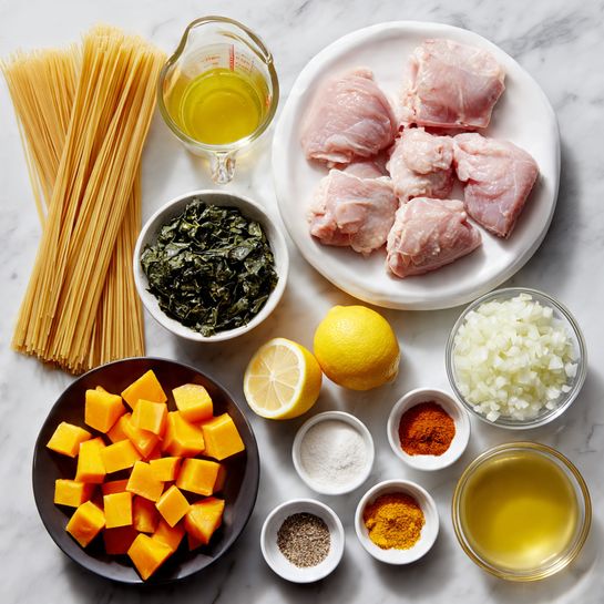 The image shows a group of cooking ingredients arranged neatly on a white marbled surface. In the center, there is a white plate holding three raw pink chicken pieces. To the top left of the plate are two bundles of uncooked thin pasta strands standing upright. Above the chicken, there is a clear glass measuring cup filled with light yellow broth. Next to it on the right, two halves of a lemon with a yellow rind are placed. To the right of the lemon, a small clear bowl is filled with finely chopped white onions. Below that, a black plate holds dark green chopped leafy vegetables. Below the chicken plate, a white bowl contains bright orange, cubed pieces of squash or pumpkin. Surrounding the bowl and plate, there are four small white bowls with coarse salt, orange spice powder, ground black pepper, and minced ginger. There is also a small clear bowl with minced garlic and a small clear container with golden oil. At the bottom right side, there is another clear glass measuring cup filled with creamy white liquid. All items are displayed in an orderly, colorful, and fresh arrangement. Photo taken with an iphone --ar 4:5 --v 7