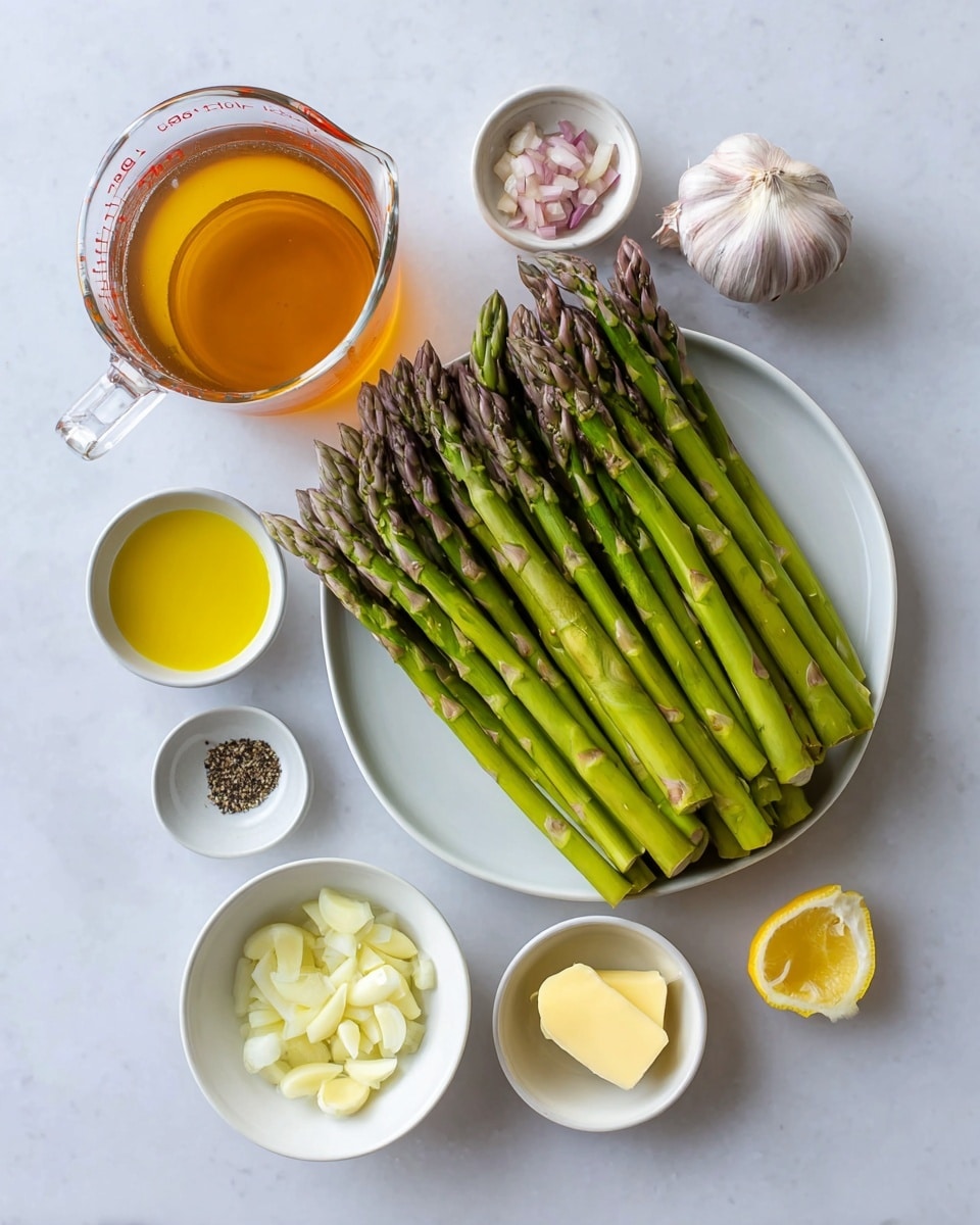 The image shows fresh green asparagus neatly stacked on a white plate, each stalk a vibrant green with purple tips, arranged horizontally. Around the plate on a white marbled surface are small white bowls containing various ingredients: a small dish of chopped shallots, a slice of bright yellow lemon in another bowl, a small amount of golden olive oil, a square piece of pale butter, two garlic cloves, one peeled and one split, and two small bowls holding black pepper and salt. At the top left, a clear glass measuring cup filled with amber-colored liquid stands out, completing the setup. The photo taken with an iphone --ar 4:5 --v 7