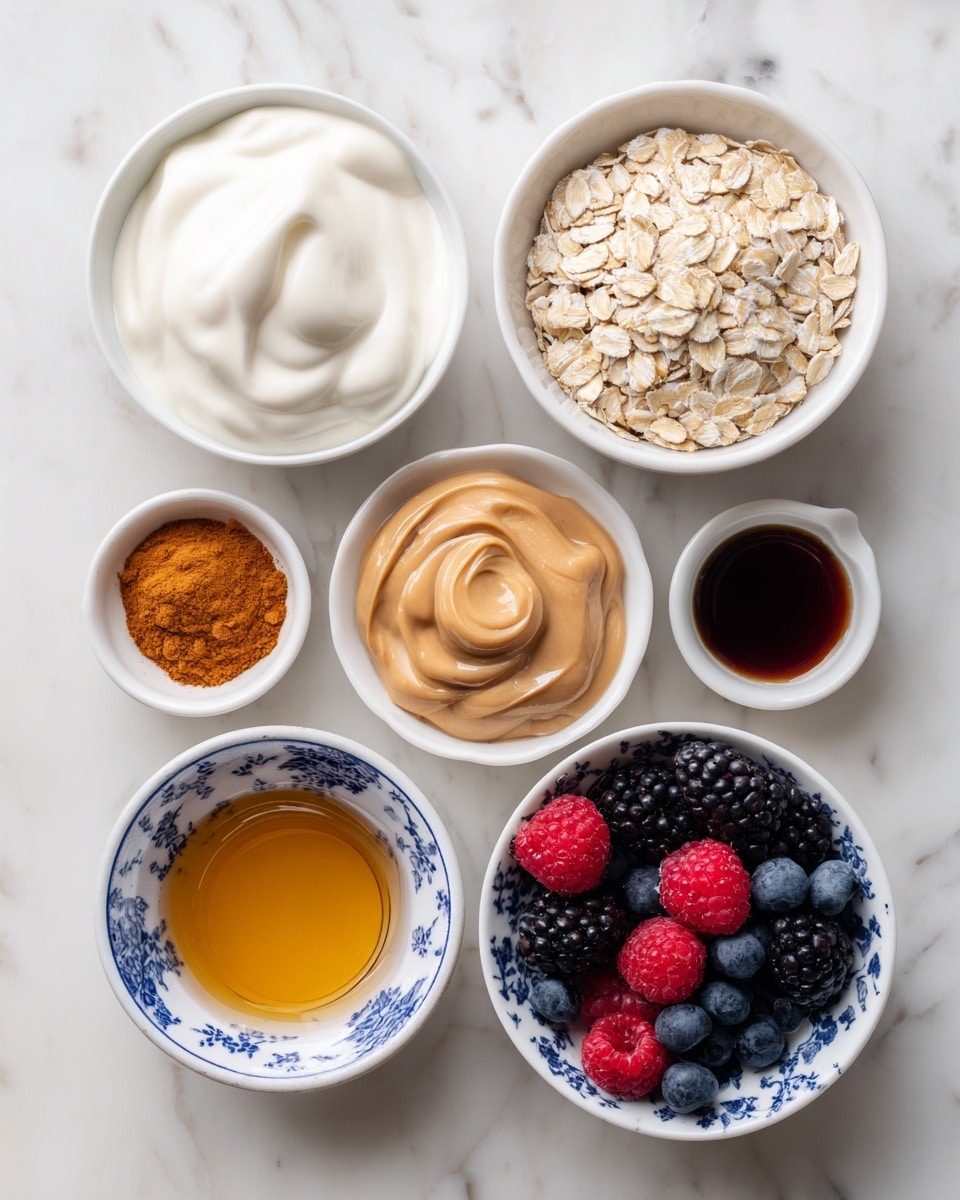 Seven small white bowls are arranged on a white marbled surface. From top left to bottom right, the first bowl contains thick, creamy white Greek yogurt with soft folds. Next to it on the right is a bowl full of pale beige oats with a dry, flaky texture. To the right of the oats is a small bowl filled with bright orange-brown cinnamon powder. Below the yogurt bowl is a bowl filled with smooth, shiny light brown nut butter. To the right is a white bowl with a blue floral pattern filled with mixed fresh berries including dark blackberries, deep blue blueberries, and bright red raspberries. Below the nut butter is a bowl with golden honey, showing its smooth and sticky texture. The last small bowl contains dark brown vanilla extract sitting as a thin liquid with a slightly reflective surface. All bowls are evenly spaced on the clean white marbled background. photo taken with an iphone --ar 4:5 --v 7