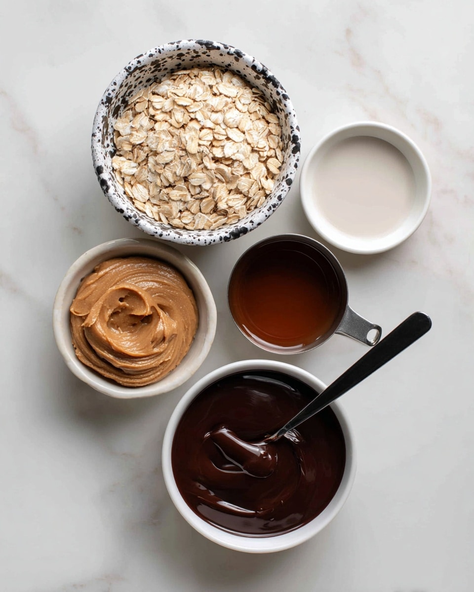 A top view of five containers holding ingredients on a white marbled surface: a white bowl with black splatter pattern filled with light beige rolled oats, a clean white small bowl with a white liquid, a metal measuring cup with smooth tan peanut butter, a metal measuring cup with a dark brown liquid, and a plain white bowl filled with dark melted chocolate with a black spoon resting inside. photo taken with an iphone --ar 4:5 --v 7