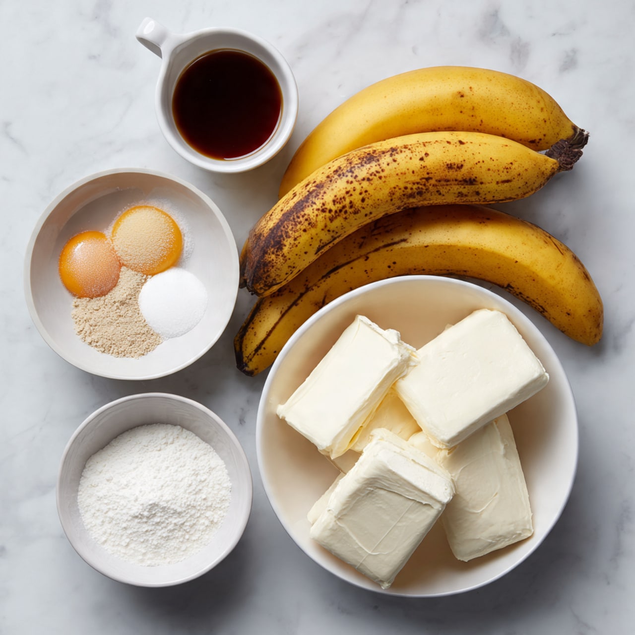 The image shows cooking ingredients arranged on a white marbled surface. On the right, there is a white bowl with three large pieces of cream cheese, smooth and soft in texture. Near the center, three ripe bananas with brown spots are placed closely together, showing a yellow and dark speckled skin. Above the bananas is a small white bowl containing four raw eggs with bright yellow yolks and clear whites. To the left of the bananas, there is a small pile of light brown powder with some white granules mixed in a white bowl, labeled as a mix of salt, nutmeg, and brown sugar. Below that, another white bowl holds white cornstarch powder. At the top left corner, a small white cup holds a dark brown liquid, labeled as a mix of vanilla extract, banana liqueur, and dark rum. All items are placed neatly on the white marbled surface. photo taken with an iphone --ar 4:5 --v 7