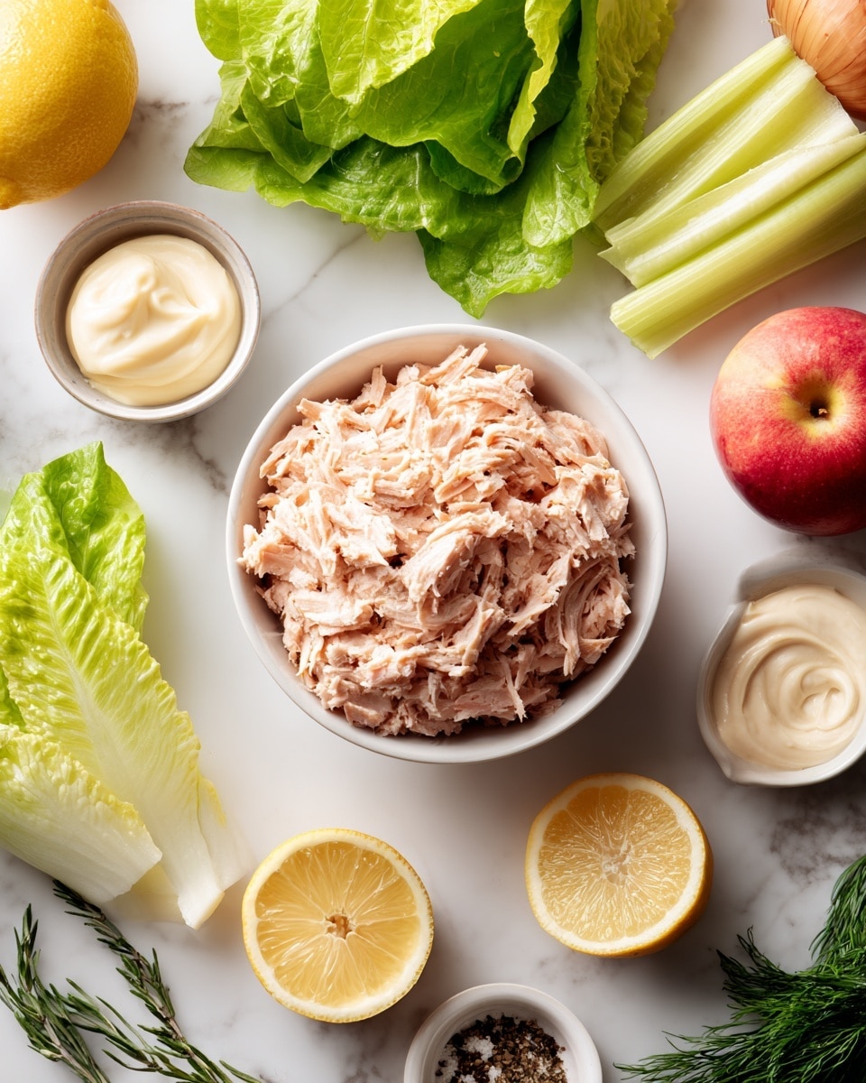 A white bowl filled with several layers of light pink shredded tuna sits in the center on a white marbled surface. Around it are fresh green lettuce leaves with a smooth texture, a pale green celery stalk, and a whole round onion with brownish-yellow skin. Nearby is a bright red apple, two halves of a lemon showing their yellow flesh, and fresh green tarragon with narrow leaves. There are also small white bowls containing creamy textures in white and pale yellow colors, a tiny bowl with light brown mustard, and a small white bowl with white salt and black pepper. The scene is well-lit and clean. photo taken with an iphone --ar 4:5 --v 7