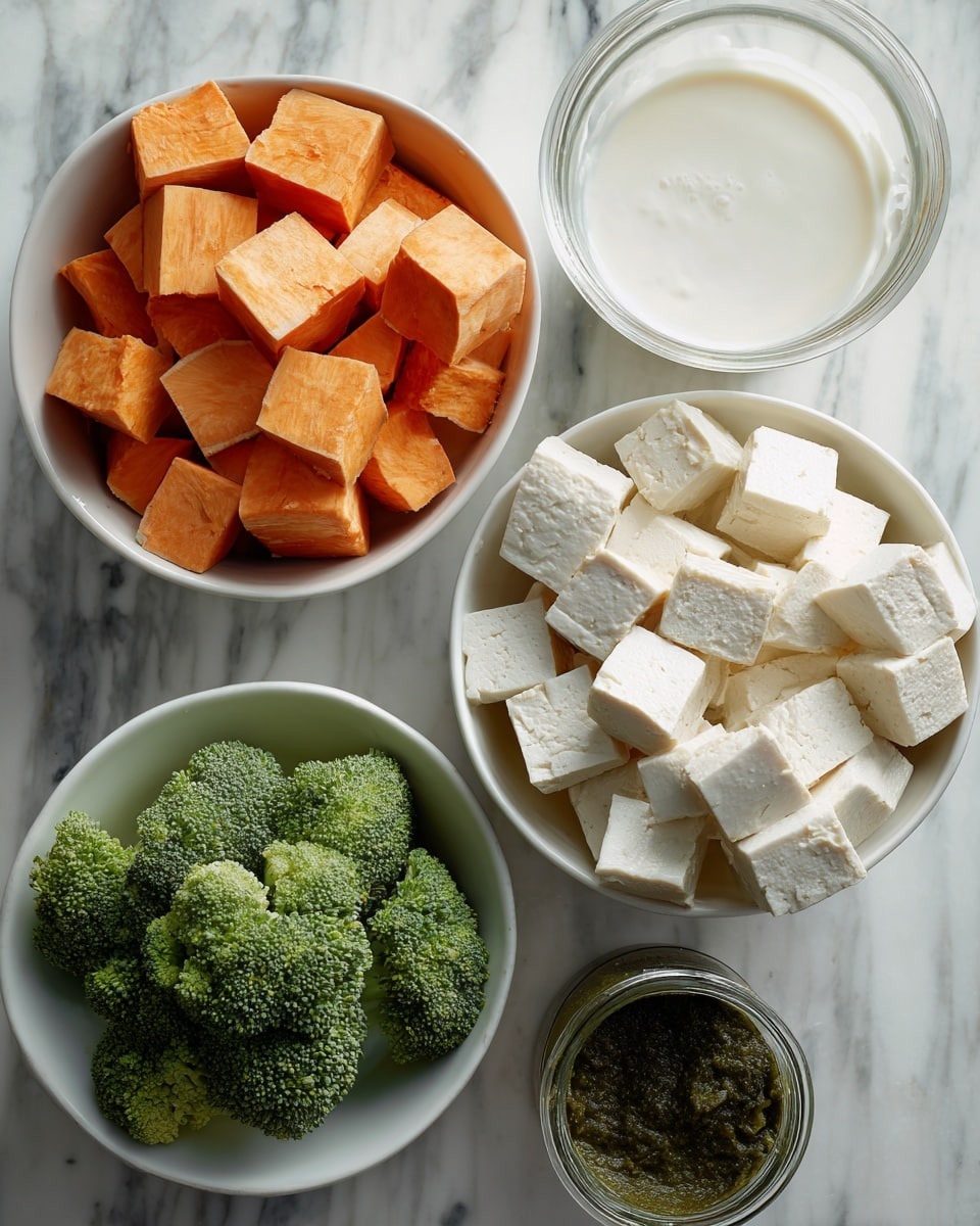 This image shows four white bowls on a white marbled surface. The top bowl holds many orange cubed sweet potatoes with a smooth texture and slightly shiny surface. To the right, another white bowl is filled with many cream-white cubes of tofu that have a soft, slightly rough texture. Below, a third white bowl contains fresh green broccoli florets with a bumpy texture and small stems. Near the center, there is an open can filled with creamy white coconut milk next to a small glass jar holding a dark green paste. photo taken with an iphone --ar 4:5 --v 7