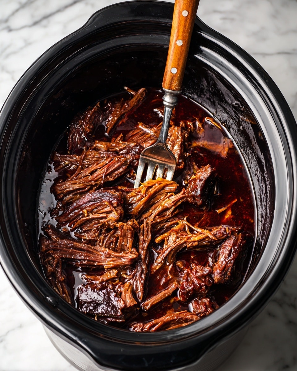 The image shows a slow cooker filled with several large pieces of dark brown shredded meat soaked in a thick, glossy dark sauce. The meat is layered close together covering the whole base of the cooker, with visible stringy texture and fibrous strands pulled apart by a silver fork with a wooden handle that is piercing and lifting some strands from the center. The inside of the cooker is black and shiny, and the slow cooker sits on a white marbled surface. photo taken with an iphone --ar 4:5 --v 7
