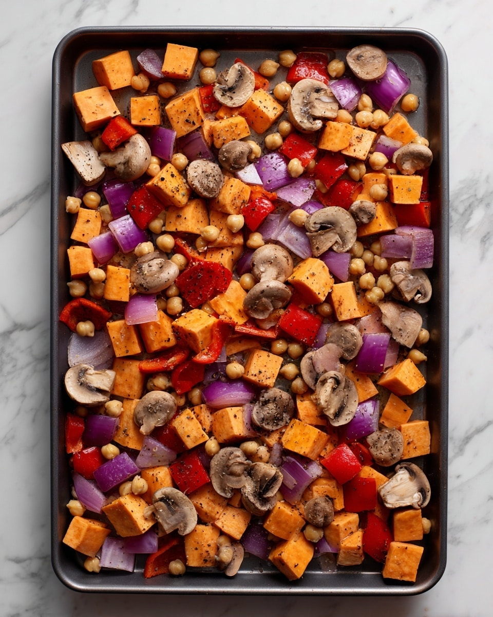 The image shows a baking tray filled with a colorful mix of chopped vegetables and chickpeas spread evenly. The vegetables include orange sweet potato cubes, red bell pepper pieces, purple-red onion chunks, and sliced brown mushrooms. The chickpeas are scattered throughout, adding a light tan round texture. Everything is coated lightly in seasoning visible as small black specks. The tray is on a white marbled surface. The photo taken with an iphone --ar 4:5 --v 7