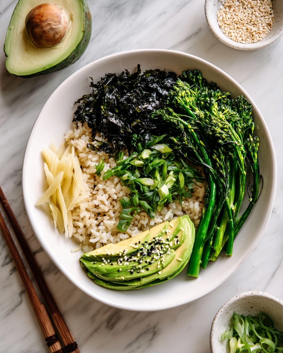 A white bowl filled with several layers starting with a base of light brown cooked rice. On top, there are small green chopped scallions mixed in with dark green seaweed strips in the center left. To the bottom left, there are thin pale yellow slices of pickled ginger with some light green microgreens beside it. The right half of the bowl features bright green broccolini stems at the top right and smooth sliced avocado fanned out below, sprinkled with white and black sesame seeds. The bowl is set on a white marbled surface with wooden chopsticks next to it, and small white bowls with green onions and sesame seeds nearby. Photo taken with an iphone --ar 4:5 --v 7