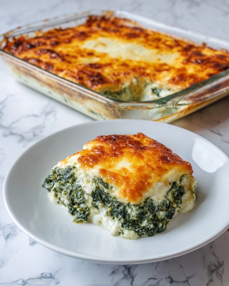 A thick square piece of spinach and cheese casserole is shown on a white plate with a simple raised border. The dish has three visible layers: the bottom layer is creamy and slightly white, the middle layer is dark green spinach mixed with white sauce, and the top layer is golden-brown melted cheese with some bubbly texture. The casserole edges appear soft and a little browned. The plate sits on a white marbled surface. photo taken with an iphone --ar 4:5 --v 7