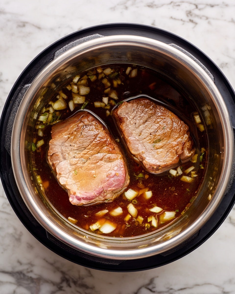 The image shows two large pieces of browned meat sitting in a stainless steel inner pot of a pressure cooker. The meat has a light brown seared surface with some pink edges visible, showing it is partially cooked. Around the meat, there is a dark brown liquid broth with many small chopped white onion pieces floating in it. The pot is inside a black pressure cooker base on a white marbled surface. photo taken with an iphone --ar 4:5 --v 7