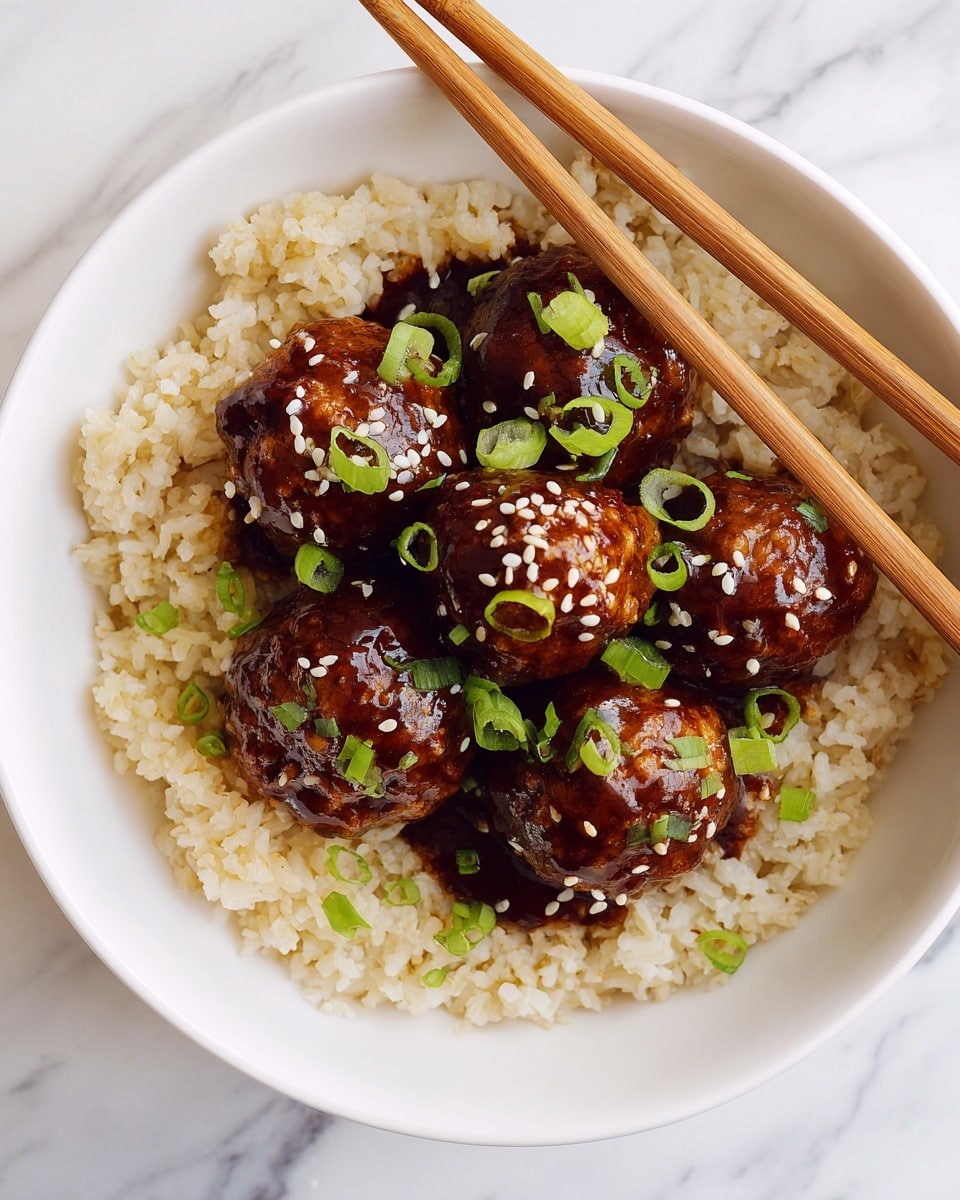A white round bowl filled with a base layer of light brown cooked rice, topped by five golden-brown meatballs coated in a shiny dark brown sauce, sprinkled with small white sesame seeds and bright green chopped scallions. Two wooden chopsticks rest on the edge of the bowl. The bowl is placed on a white marbled surface. photo taken with an iphone --ar 4:5 --v 7
