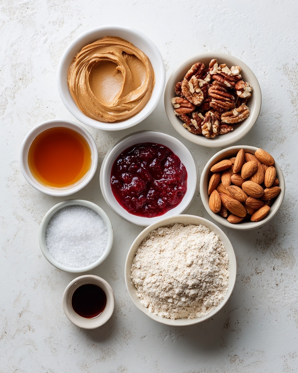 The image shows eight small white bowls arranged on a white marbled surface, each filled with a different ingredient. Starting from the top left, there is a bowl of smooth, light brown peanut butter with a creamy texture. To its right, a bowl holds medium brown pecans with rough, bumpy surfaces. Below the peanut butter, a bowl contains amber-colored maple syrup with a shiny, liquid surface. Next to it is a bowl filled with deep red strawberry jam, thick with visible seeds and fruit pieces. To the right of the jam, an off-white bowl is full of oat flour, showing a powdery texture with small clumps. Beneath the maple syrup, a bowl displays whole almonds with dark brown, slightly rough skin. Next to it, a tiny bowl holds white salt crystals, fine and slightly granular. Finally, a small bowl contains dark brown vanilla extract with a glossy liquid surface. All bowls are evenly spaced on the white marbled background. Photo taken with an iphone --ar 4:5 --v 7