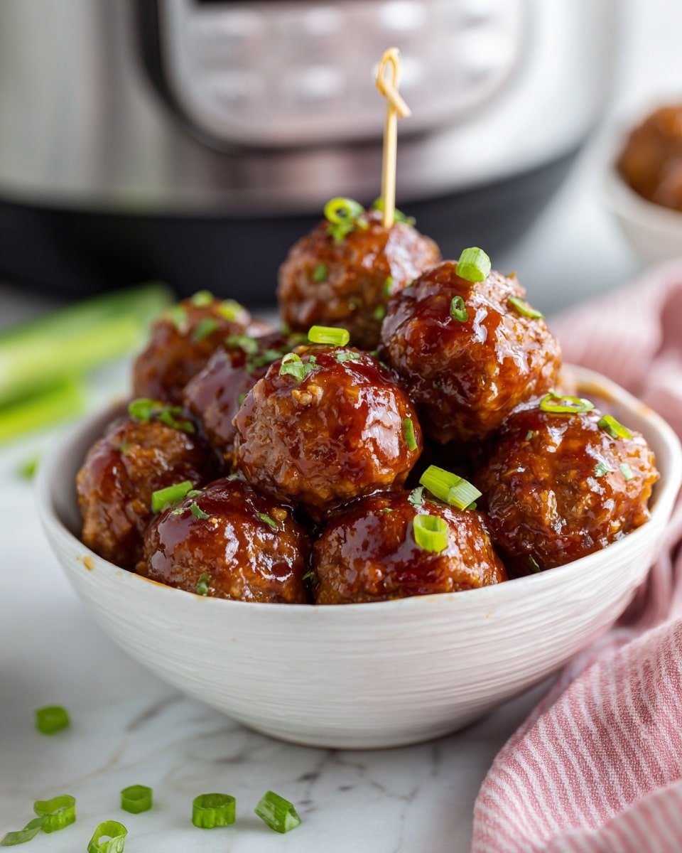 A white bowl filled with about three layers of shiny, brown meatballs coated in a glossy sauce, sprinkled lightly with small green onion pieces. A toothpick is stuck into the top meatball. Some green onion pieces are scattered on the white marbled surface around the bowl. In the blurred background, there is a stainless steel slow cooker with a digital display. A soft pink and white striped cloth lies in the foreground on the right side. photo taken with an iphone --ar 4:5 --v 7
