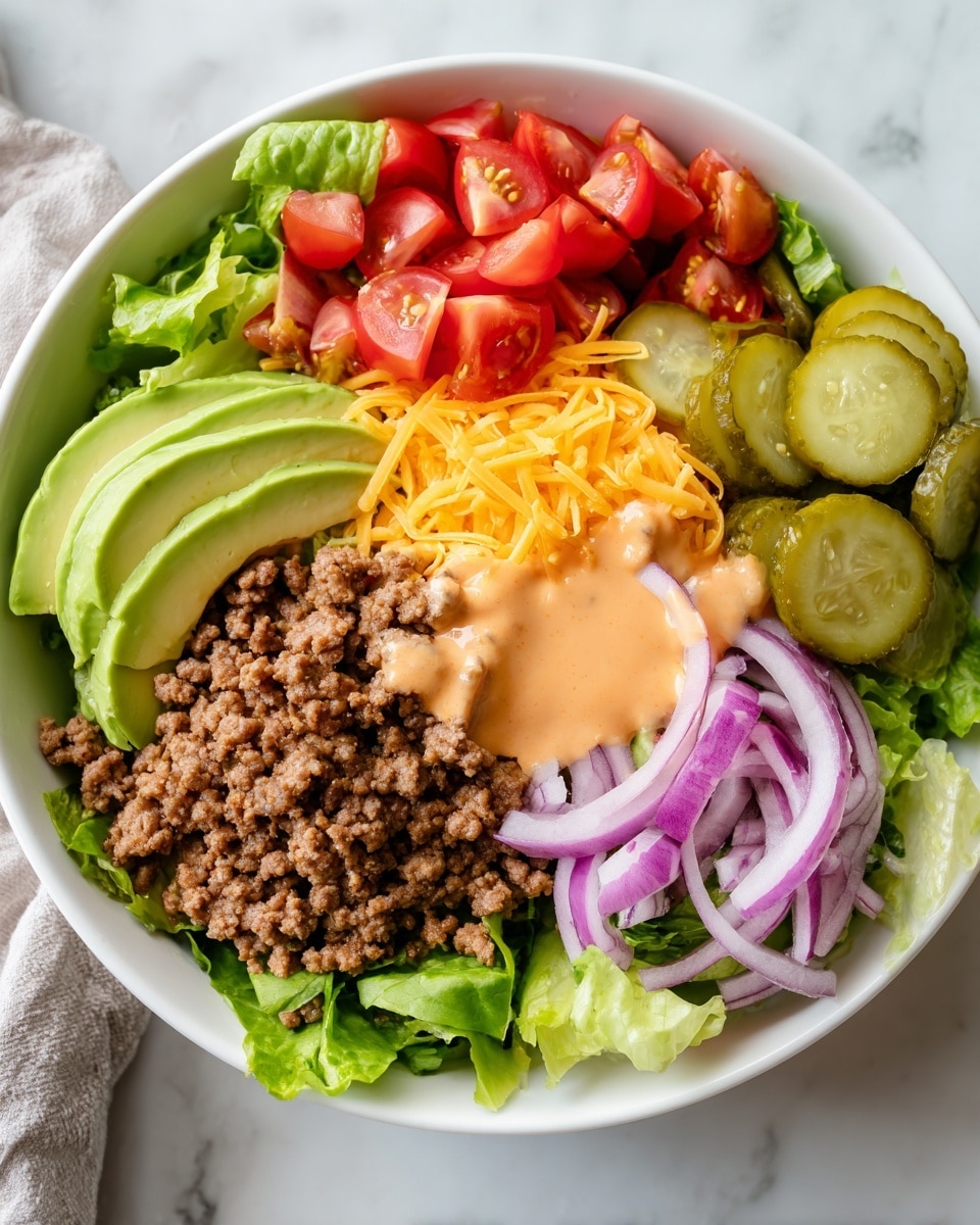 A fresh salad is shown in a deep white bowl on a white marbled surface. The base layer is a mix of green lettuce and romaine leaves with bright red halved cherry tomatoes scattered around. Above this is a layer of cooked ground beef at the center. On top of the beef are slices of creamy green avocado on one side, thin rings of purple-red onion on the other, and a small pile of shredded orange cheddar cheese near the onions. In the front, thick sliced green pickles add another layer. The whole salad is lightly drizzled with a creamy light orange dressing that flows gently over the lettuce, beef, avocado, pickles, and tomatoes. Photo taken with an iphone --ar 4:5 --v 7