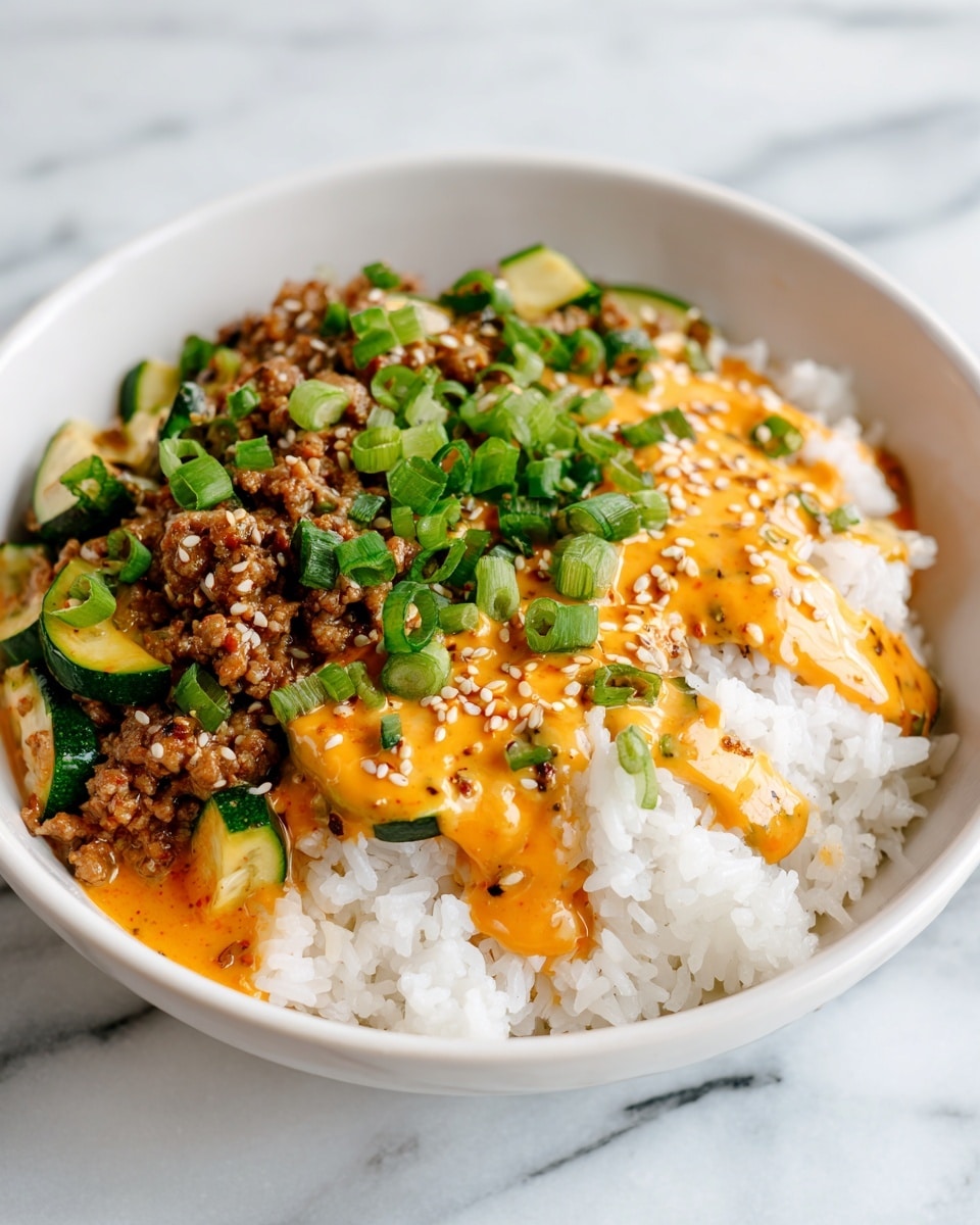 A white bowl is filled with two main layers; on the right side is a fluffy layer of white rice topped with an orange sauce drizzled unevenly and sprinkled with sesame seeds. On the left side is a mix of cooked ground meat and bite-sized green zucchini pieces, all covered with the same orange sauce and green sliced scallions scattered on top. The bowl is placed on a white marbled surface. photo taken with an iphone --ar 4:5 --v 7