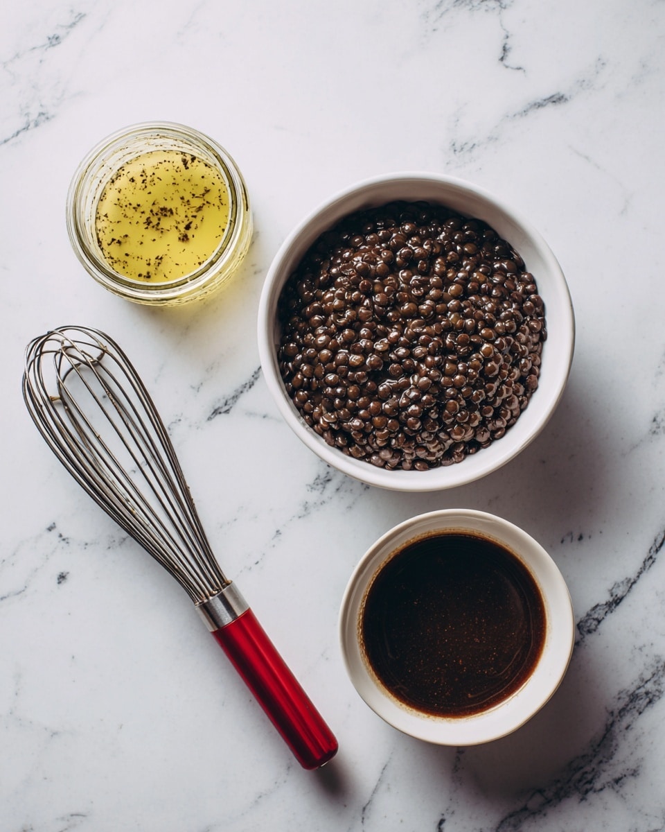 The image shows a white bowl filled with dark brown cooked lentils placed on the right side of a white marbled surface. Next to it, there is a small white mixing bowl containing a dark brown textured sauce or liquid. On the left side, a whisk with a red handle lies on the surface, and an open glass jar with some yellowish content is placed at the top left. The overall setting is neat and simple with all items resting on the white marbled background photo taken with an iphone --ar 4:5 --v 7
