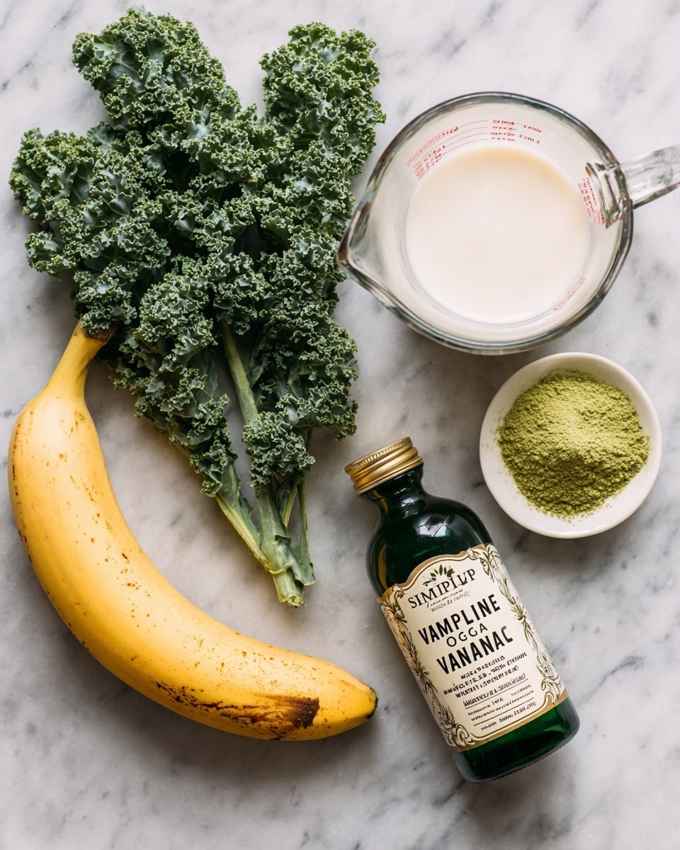 The image shows five ingredients arranged on a white marbled surface. On the left, there is a bunch of fresh green curly kale leaves with a textured surface. Near the center, a clear glass measuring cup filled with creamy white milk is placed at the top. Below it, a ripe yellow banana with some brown spots rests horizontally. To the right of the banana, there is a small white plate with a bright green powder, which looks finely ground. At the bottom right corner, a dark green-tinted bottle labeled