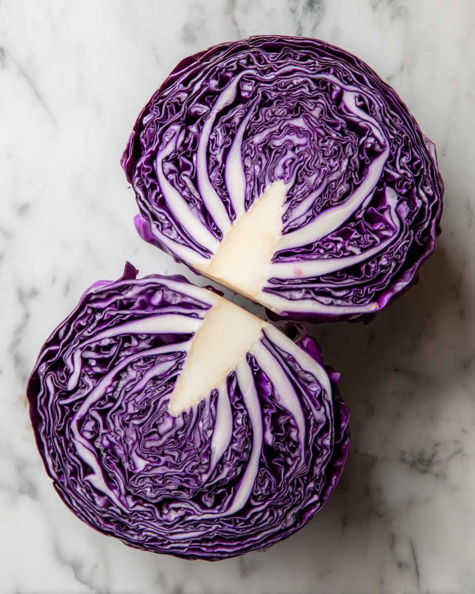 The image shows two halves of purple cabbage with their dense, curly inner leaves revealed. Each cabbage half has multiple layers, with deep purple and white veins creating a patterned texture. The thick white core sits in the center of each half, spreading out like fingers into the purple leaves. Around the cabbage halves are parts of a green apple, a red apple, and an orange. All of this is set on a white marbled surface. photo taken with an iphone --ar 4:5 --v 7