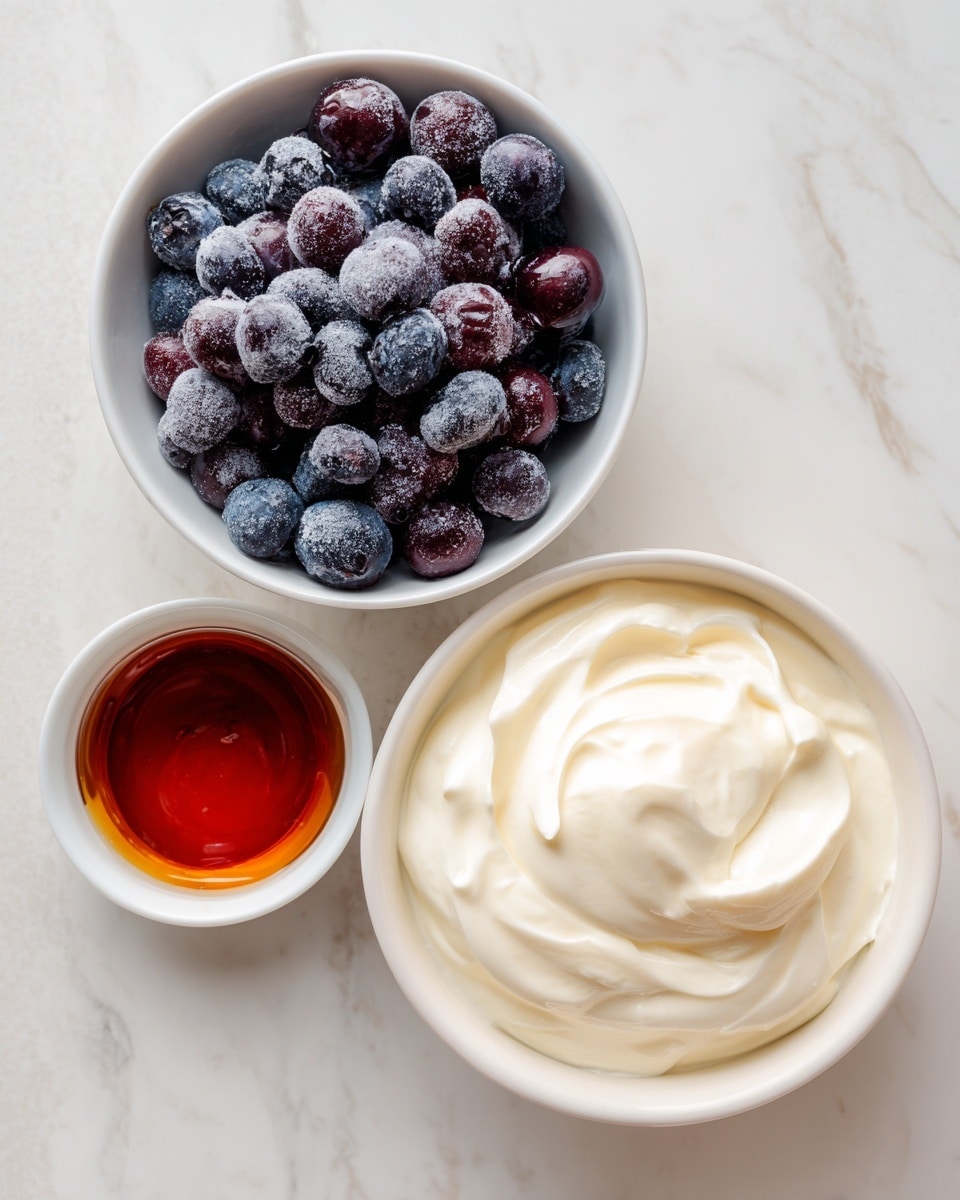 The image shows three white bowls on a white marbled surface. The top left bowl is filled with round frozen blueberries covered slightly in frost, showing deep purple and blue shades. To the right, a larger bowl holds smooth and thick Greek yogurt with soft swirls on its surface in a creamy white color. Below these, a small white bowl contains dark amber maple syrup with a glossy surface that catches the light. Each bowl is labeled clearly with black text on white background, positioned across the contents. photo taken with an iphone --ar 4:5 --v 7