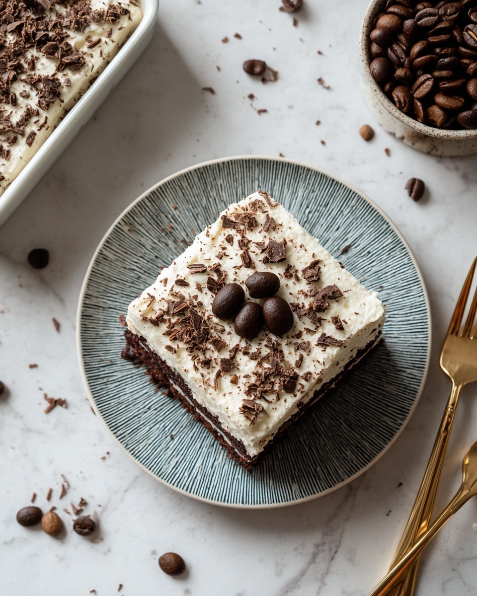 A square piece of chocolate cake with one thick layer, topped with a smooth light cream layer that covers the entire piece, sprinkled with dark chocolate shavings and three dark brown coffee beans arranged in the center. The cake is on a white plate with a blue textured pattern, set on a white marbled surface. In the top left corner, the remaining cake is in a white square baking dish. To the right, there is a round container filled with dark brown coffee beans. Two gold forks lie near the container, with a few scattered coffee beans around them. photo taken with an iphone --ar 4:5 --v 7