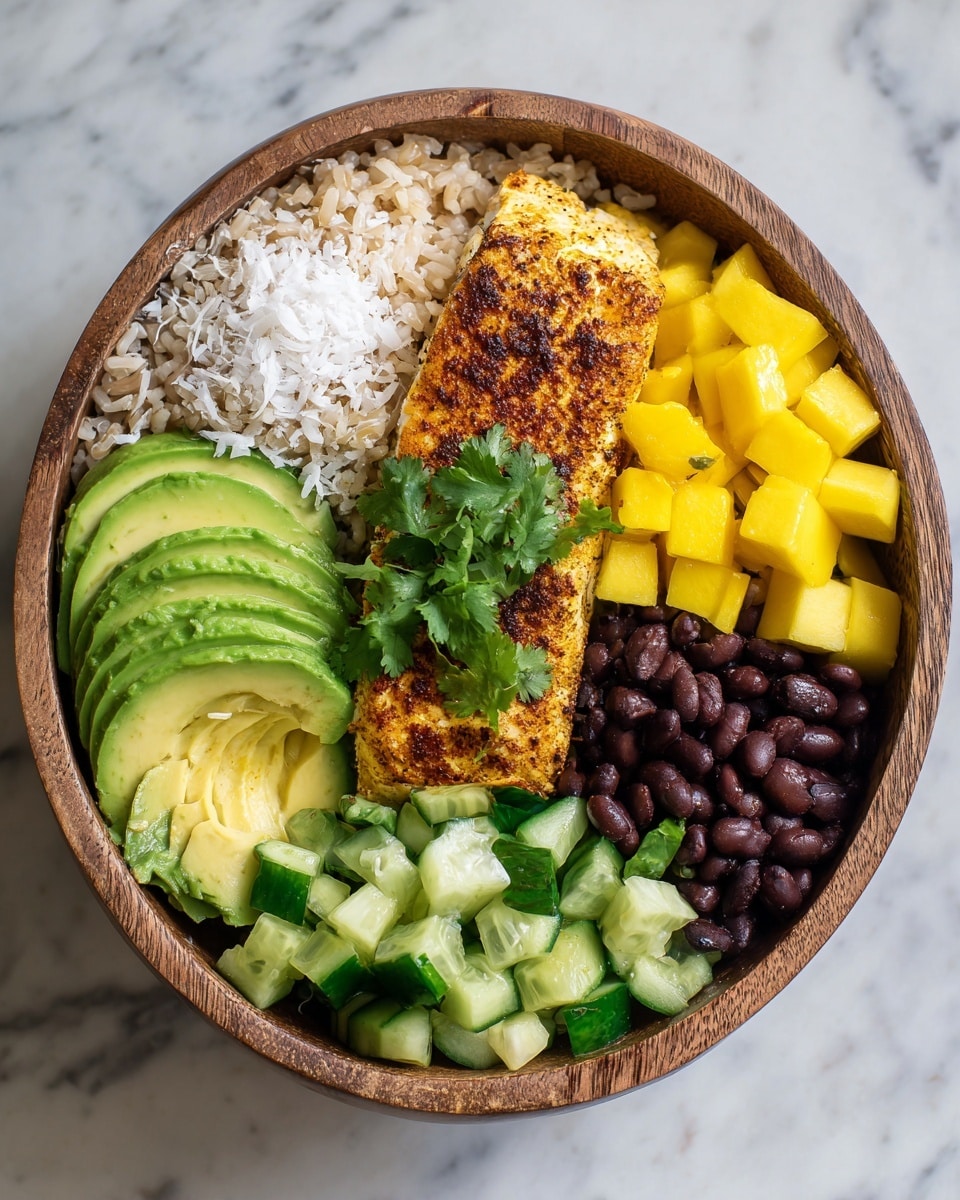 A clear round bowl on a white marbled surface holds a colorful dish with six visible layers: at the bottom is light brown rice, topped partially with big white coconut flakes on the left side. On the right side of the bowl, bright yellow mango cubes sit next to dark black beans. Below the mango are small green cucumber chunks with some seasoning, and next to the rice on the left sits sliced avocado pieces arranged in a neat row. In the center, a large golden brown seasoned piece of fish rests on top of the layers, garnished with a few sprigs of fresh green cilantro. Photo taken with an iphone --ar 4:5 --v 7