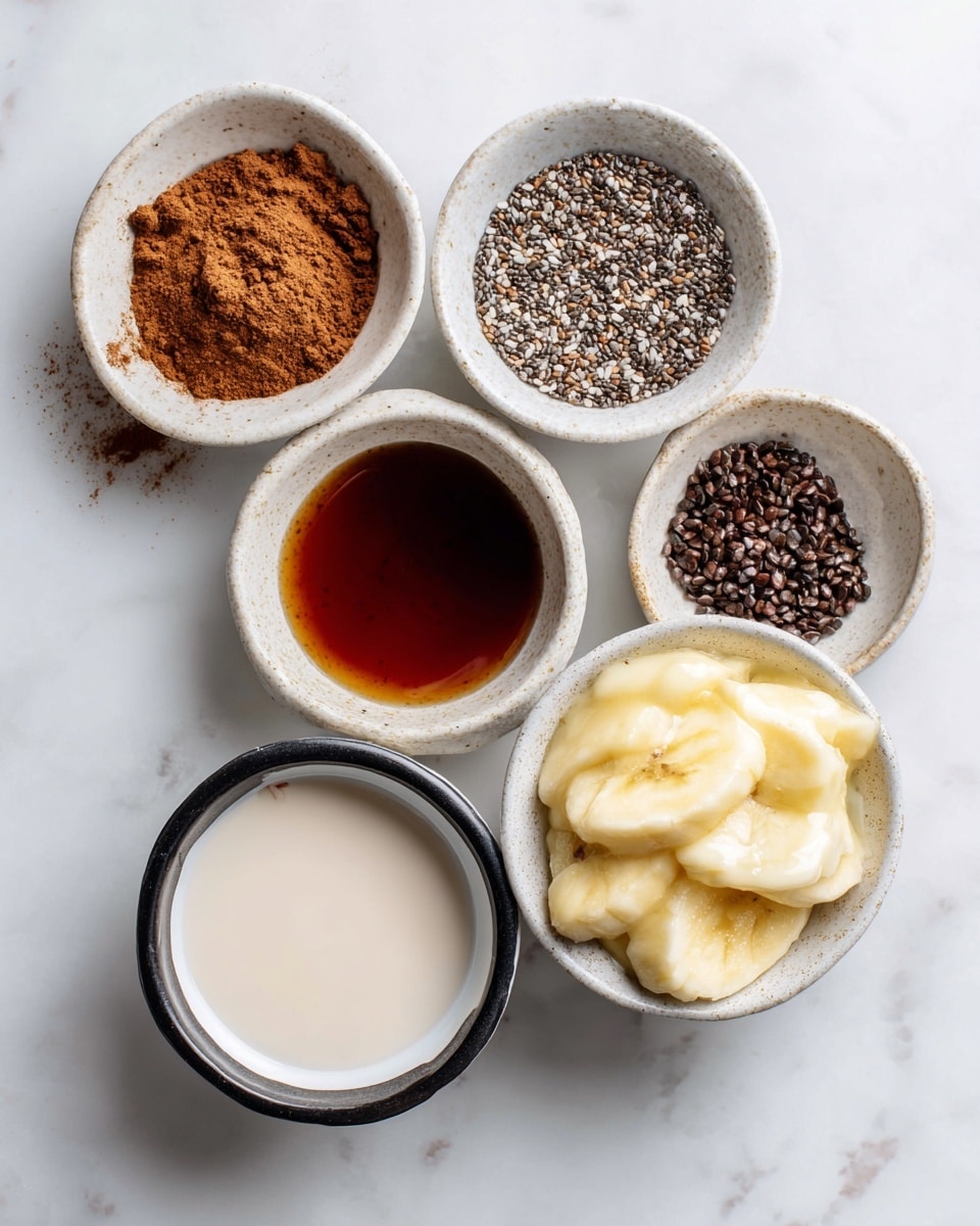 The image shows six small white bowls arranged on a white marbled surface, each with a different ingredient inside. The top left bowl contains a small pile of brown cinnamon powder with a fine texture. To its right, a bowl is filled with tiny, dark brown and light gray chia seeds that have a rough, grainy texture. Below the cinnamon, there is a bowl with dark amber vanilla extract, smooth and shiny. In the center, a bowl holds creamy and pale almond milk. Below the vanilla, a bowl is filled with dark maple syrup that has a thick, glossy surface. At the bottom right, a white bowl with a black rim contains mashed yellow banana with a soft, slightly chunky texture. photo taken with an iphone --ar 4:5 --v 7
