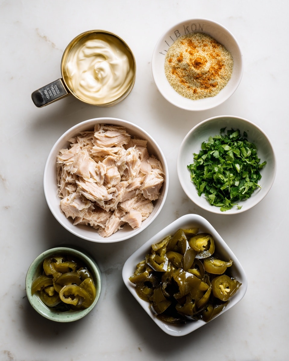 The image shows seven separate white bowls and a measuring cup placed on a white marbled surface, each holding different ingredients: the largest bowl at the bottom contains chunked light beige canned tuna; above it to the left is a gold-colored measuring cup with creamy white mayo; next to it on the upper right is a medium white bowl filled with beige and orange seasoning mix; below the seasoning is a small white bowl with bright green chopped cilantro; to the right of the cilantro is a square white bowl filled with shiny dark green jalapeno pieces; above the tuna bowl to the left is a small greenish bowl containing sliced jalapeno or pickle pieces in a liquid; the items are neatly arranged with labels identifying each component photo taken with an iphone --ar 4:5 --v 7