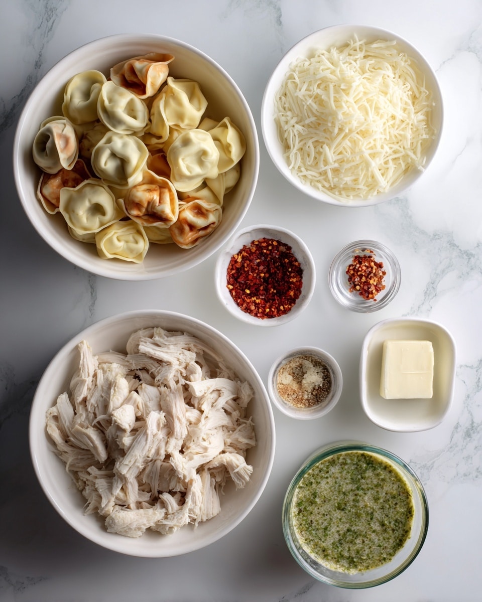 The image shows a white bowl filled with tri-colored tortellini placed at the top left corner over a white marbled surface. Below it, there is a larger white bowl filled with shredded chicken. To the right of the tortellini bowl, there is another white bowl with shredded mozzarella cheese. In the middle, three small white bowls contain red pepper flakes, minced garlic, and Italian seasoning. At the bottom right, a small white bowl holds a square of butter next to another bowl with green pesto sauce. A clear measuring cup filled with heavy cream is near the bottom center. On the far left, a carton of chicken broth sits against the surface. Each ingredient is neatly arranged in separate white bowls or containers, cleanly placed on the white marbled background. photo taken with an iphone --ar 4:5 --v 7