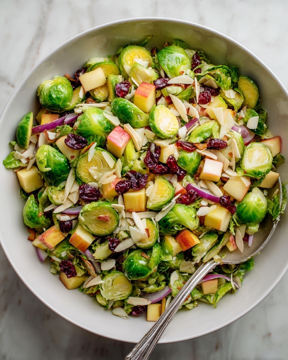 A top view of several small white bowls and two clear bowls arranged on a white marbled surface, each containing different ingredients: one clear bowl holds halved green Brussels sprouts, another clear bowl contains red and yellow apple chunks, a small wooden bowl is filled with sliced almonds, a small white bowl with light yellow olive oil, a small wooden bowl with a dollop of Dijon mustard, a small white bowl with golden honey, a small white bowl with two thick pieces of pale yellow Manchego or Parmesan cheese, a small white bowl with coarse salt and pepper, a small white bowl with light brown apple cider vinegar, a halved red onion placed directly on the surface, and a small white bowl filled with dark red dried cranberries, each ingredient clearly visible and distinct photo taken with an iphone --ar 4:5 --v 7