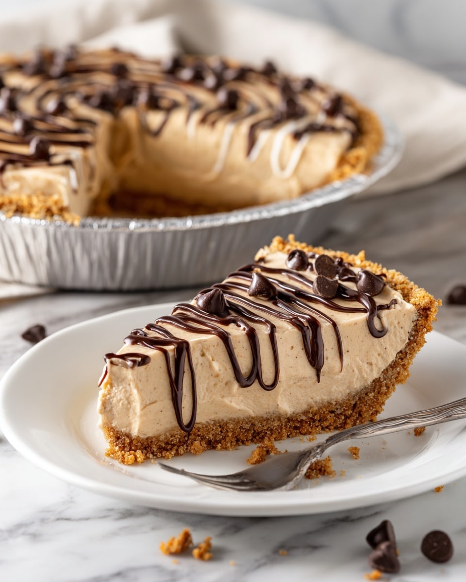 Two slices of creamy light brown pie with a crumbly crust sit on a white plate, each slice topped with thin swirls of darker brown drizzle and a few chocolate chips. The pie has about two visible layers: the crust at the bottom with a rough texture, and the smooth, thick filling above it. In the background, a larger pie with the same filling and crust sits in a foil pan on a white marbled surface. Near the plate, a few loose chocolate chips and crumbs are scattered, and a fork holds a small bite-sized piece of pie. Photo taken with an iphone --ar 4:5 --v 7