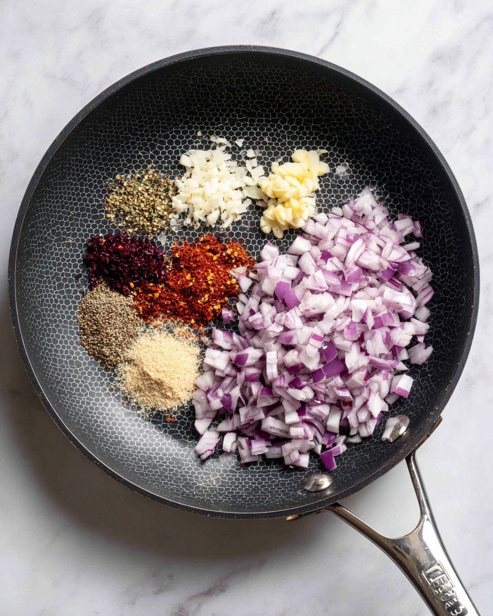 A black frying pan with a honeycomb pattern in the center holds a mix of chopped purple and white onions scattered mostly on the right side. On the left side, there are five different spices neatly grouped in small piles, showing shades of white, red, brown, and beige. In the middle-right area, small pale yellow pieces of minced garlic rest atop the onion pieces. The pan’s handle is silver with a black grip, and the pan is placed on a white marbled surface. photo taken with an iphone --ar 4:5 --v 7