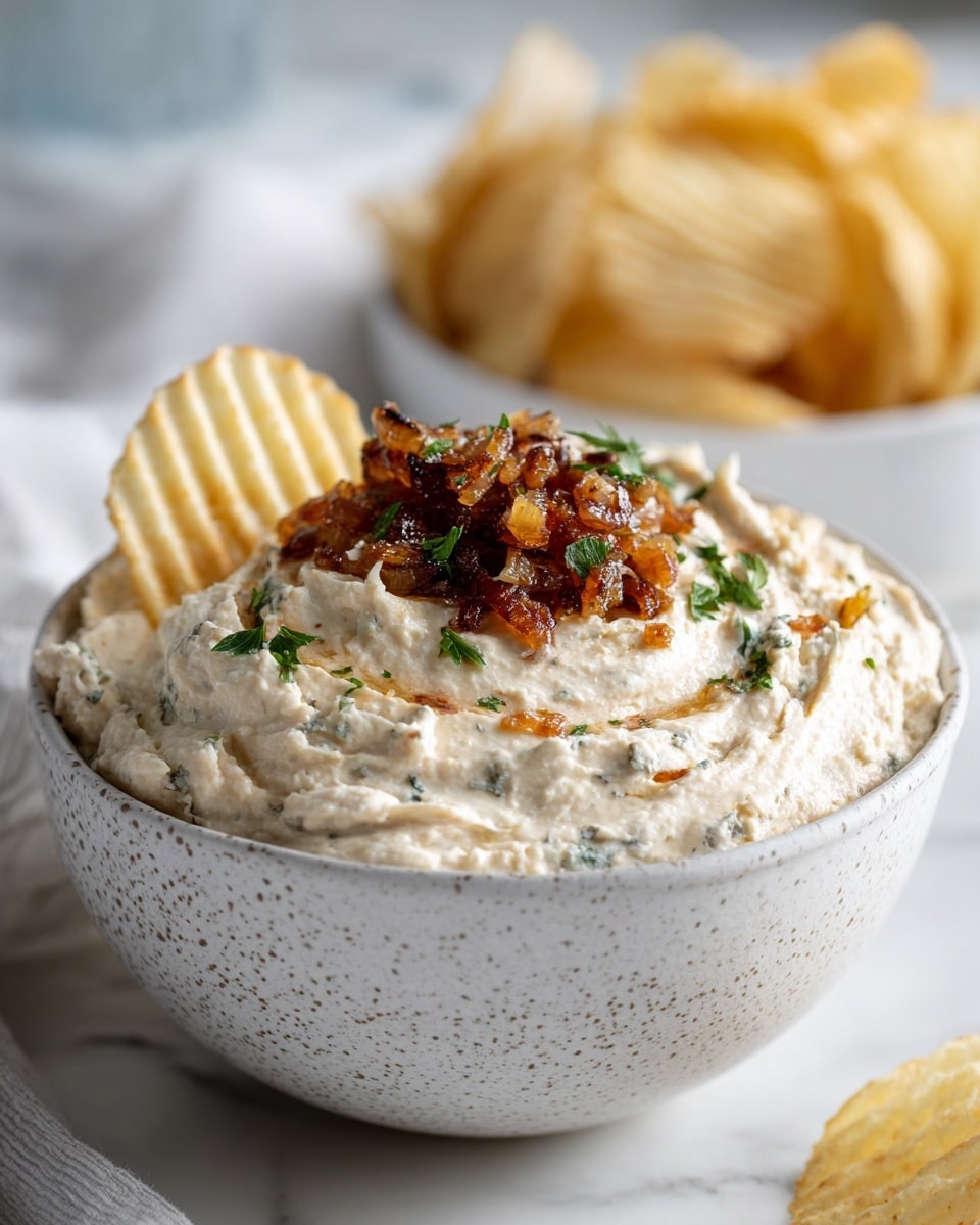 A close-up shows a woman's hand holding a ridged potato chip dipped in thick, creamy white dip with small herb pieces and some green parsley on top. The dip sits in a white bowl with brown speckles on the rim. In the blurred background, there is a white bowl filled with more ridged potato chips. The whole scene is set on a white marbled surface. photo taken with an iphone --ar 4:5 --v 7