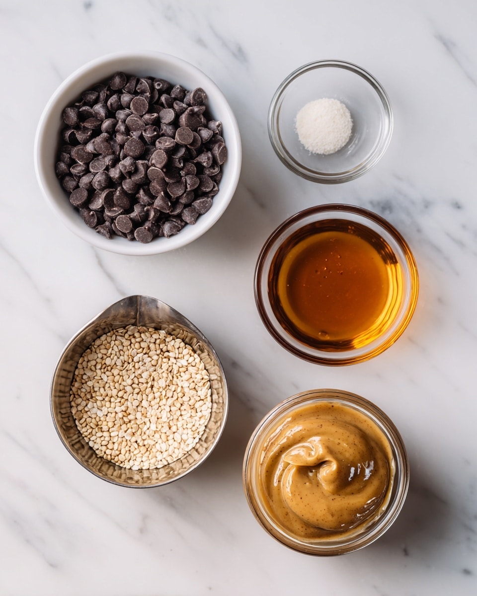 The image shows five small containers placed on a white marbled surface. On the left is a white bowl filled to the top with small dark chocolate chips, smooth and round. To the right of it, near the top, is a clear glass bowl holding a small round white powdery piece. Below this is another clear glass bowl with a dark amber liquid inside. At the bottom left, there's a stainless steel measuring cup filled with small beige seeds, and next to it on the right is another stainless steel measuring cup filled with thick, light brown almond butter that looks creamy with some small bubbles on the surface. photo taken with an iphone --ar 4:5 --v 7