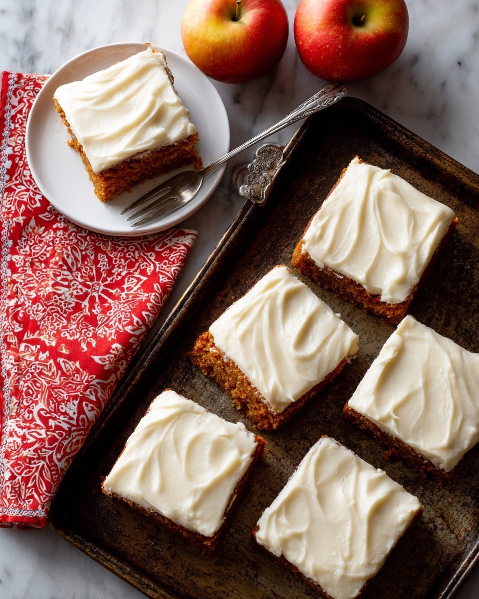The image shows six square pieces of carrot cake arranged in two rows of three on a dark rustic tray. Each cake piece has one thick layer of cream cheese frosting on top, smooth with gentle swirling texture in white color. To the left, one piece of cake sits on a white plate with a silver fork next to it on the plate’s edge. A red bandana cloth with white patterns is partially underneath the plate. At the top, there are two red apples with a yellowish tint placed close together on the tray. The background is a white marbled surface visible around the tray edges. photo taken with an iphone --ar 4:5 --v 7