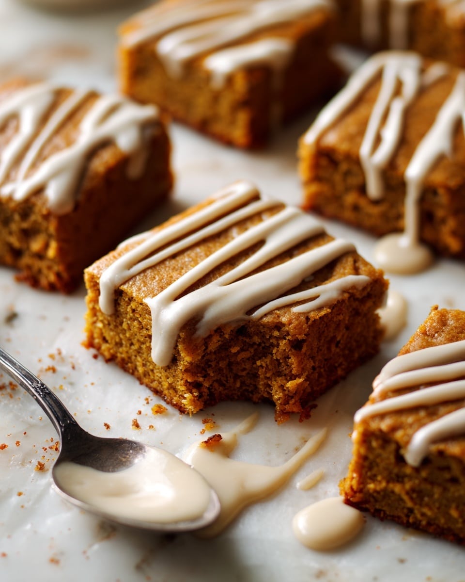 A close-up view of several square pumpkin bars laid out on a white marbled surface, each bar with a soft, moist texture and a rich orange-brown color showing warm spices inside. The bars are drizzled with light beige icing in thin, uneven stripes across the top. A silver spoon rests nearby with more of the light beige icing on it, some icing is spilled onto the surface. The pumpkin bars have slightly rough edges and a cozy, homemade feel. photo taken with an iphone --ar 4:5 --v 7