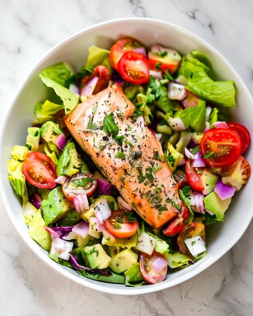 A white bowl filled with a fresh salad layered with green lettuce leaves covering the bottom, topped with chunks of light green avocado and red cherry tomato halves scattered around. Diced purple onion pieces are sprinkled throughout, adding color contrast. In the center lies a piece of cooked salmon, light pink with herbs and black pepper sprinkled on top. The salmon has a slightly shiny, moist texture. The bowl sits on a white marbled surface. photo taken with an iphone --ar 4:5 --v 7